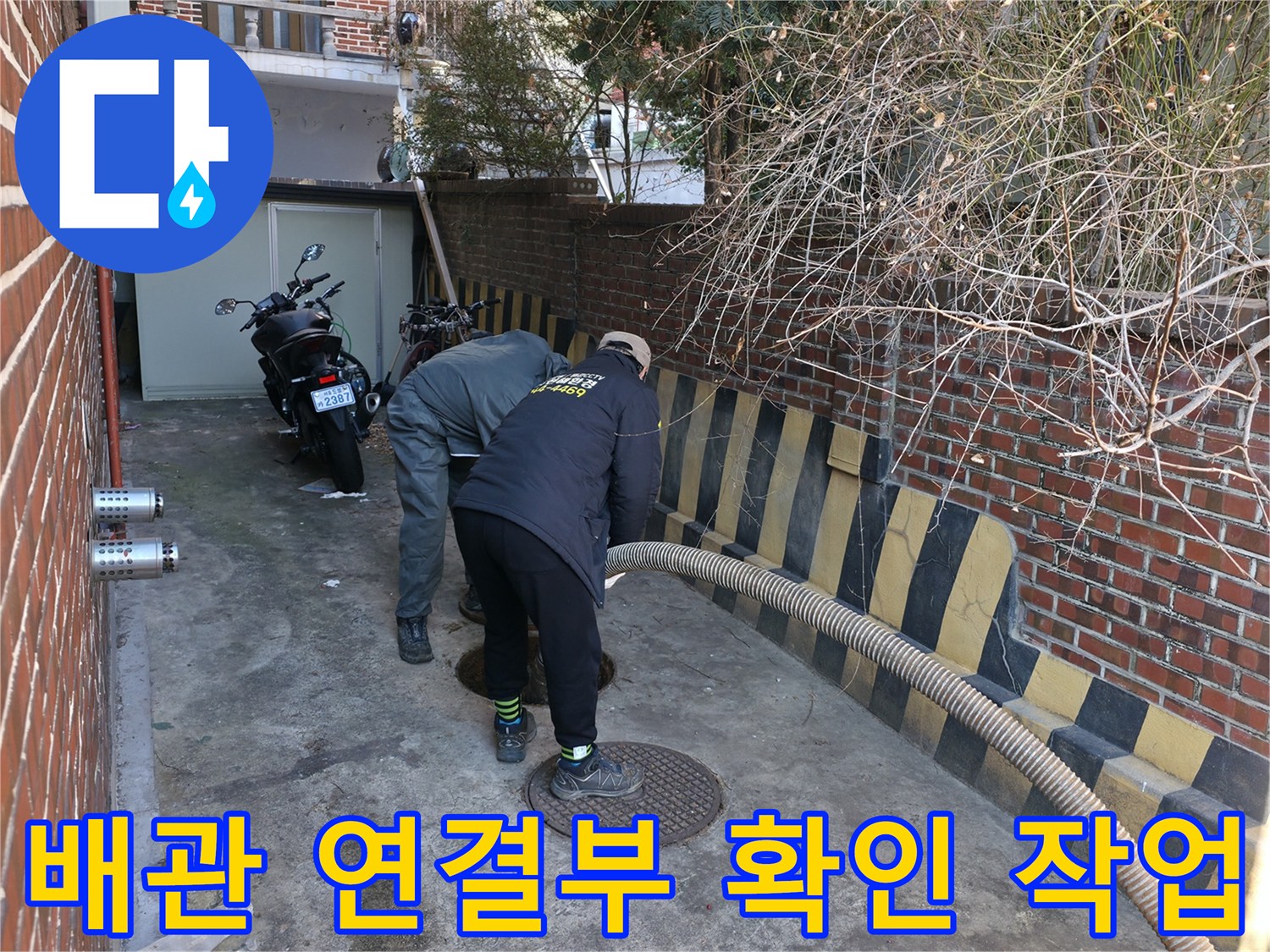 외부 배관-맨홀 덮개 근처의 오염 상태를 점검하는 기술자