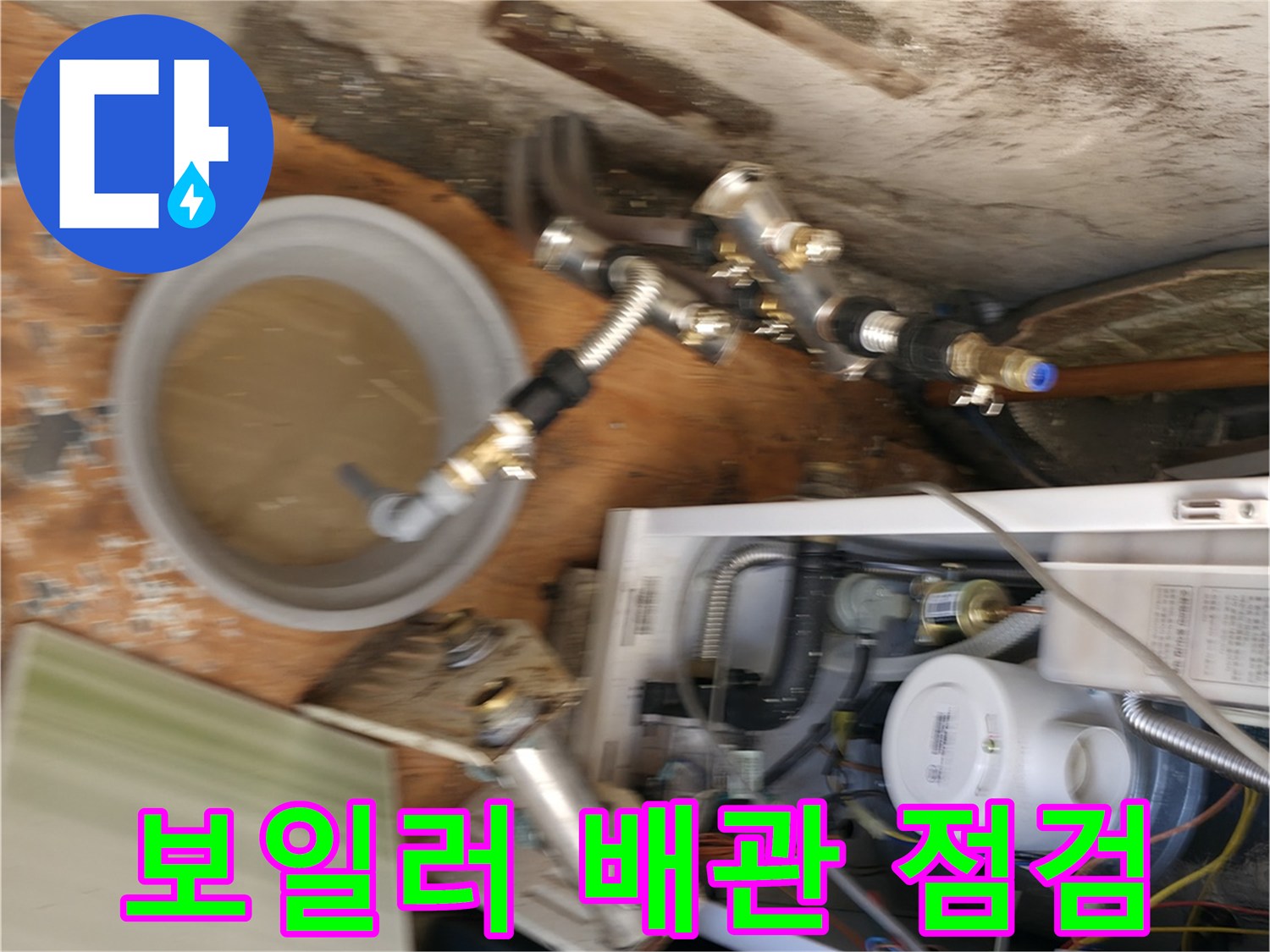 보일러 아래쪽 배관과 물이 담긴 양동이 사진
