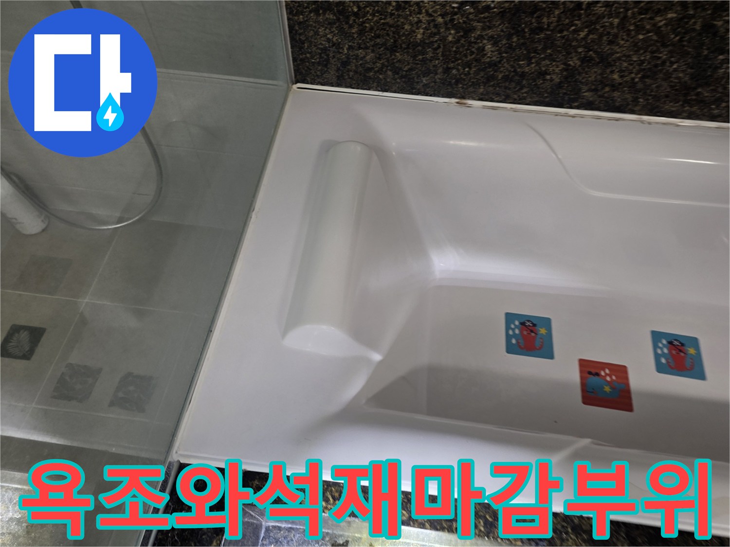 하얀색 욕조와 어두운 색상의 상단 마감재 접점