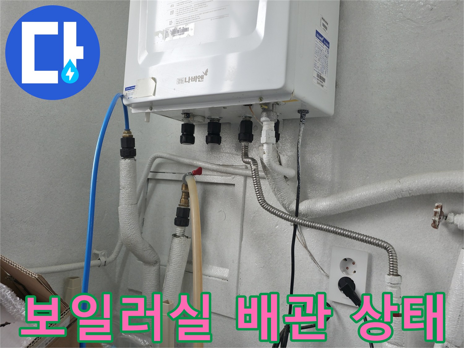 보일러 하단에 연결된 다양한 종류의 배관과 호스 모습