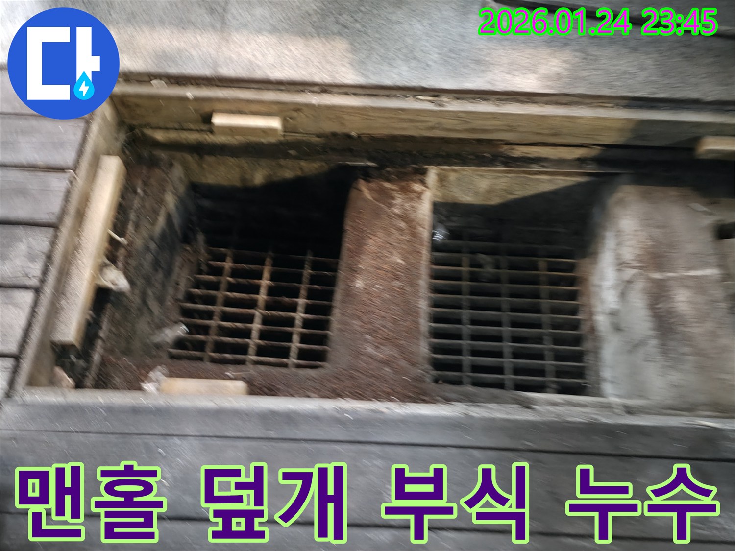 노후된 맨홀 덮개 주변에서-부식으로 인해 발생한 누수를 점검하는 사진입니다.