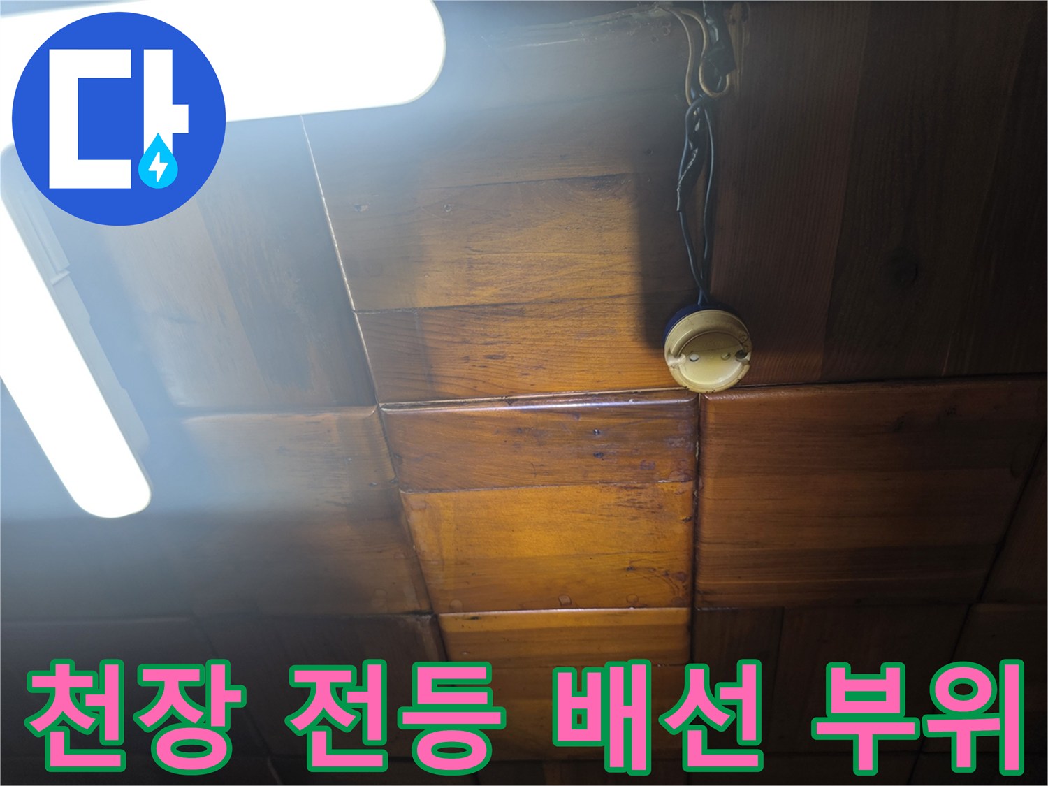 천장 조명 근처의 노출된 전선과 나무 마감재