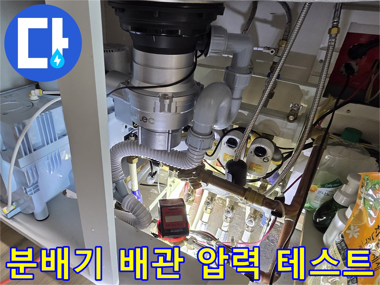싱크대-하부장-내부의-금속-분배기와-연결된-수도-배관들