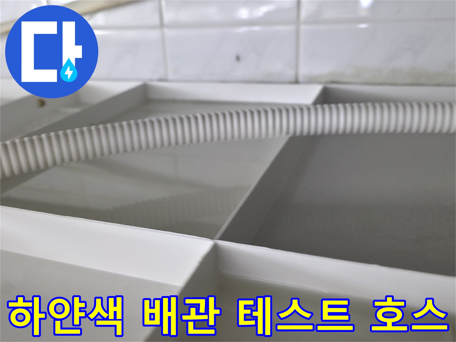 누수 지점을 찾기 위해 배관에 연결되어 있는 흰색 주름 호스