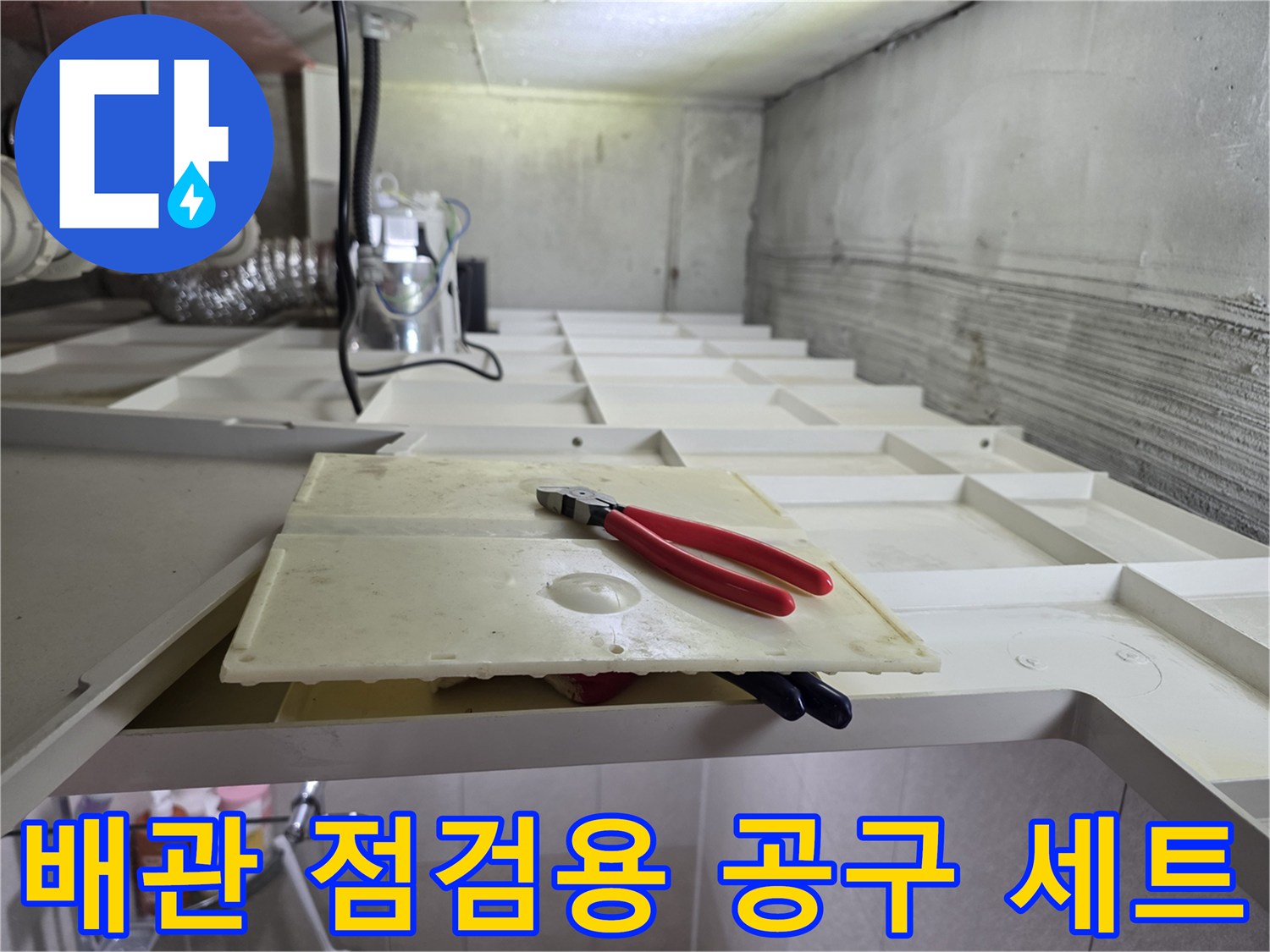 천장 내부 배관 근처에 놓인 펜치와 흰색 작업 판