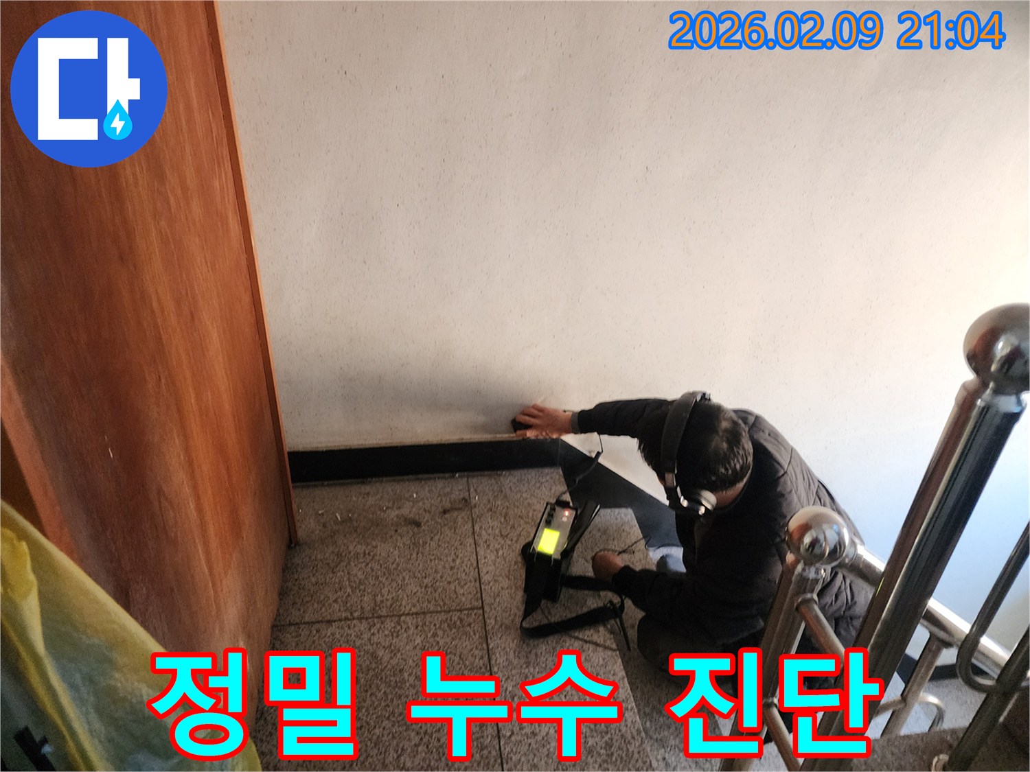 전문-누수-탐지사가-첨단-음향-탐지-장비를-사용하여-벽면-내부의-누수-지점을-정밀하게-찾아내는-작업-현장