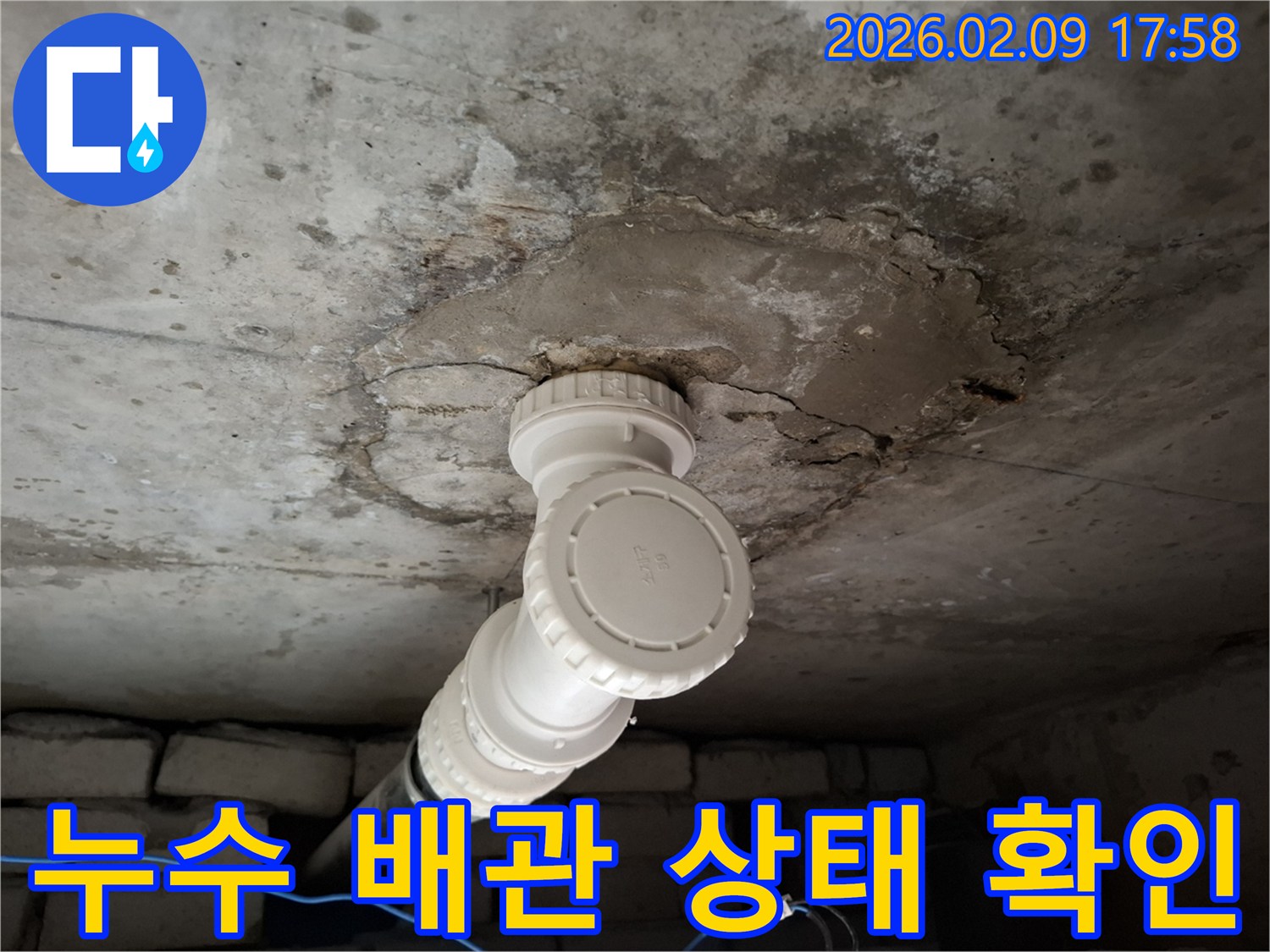 천장 콘크리트에 설치된 배관-누수로 인한 손상 부위를 면밀히 관찰하는 사진