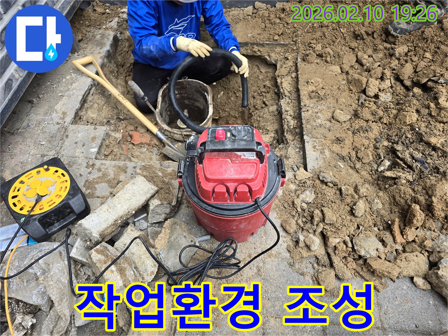 상가 누수 현장에서-굴착된 공간의 흙과 물기를-진공 청소기로 흡입하여 정리하는 작업자입니다.