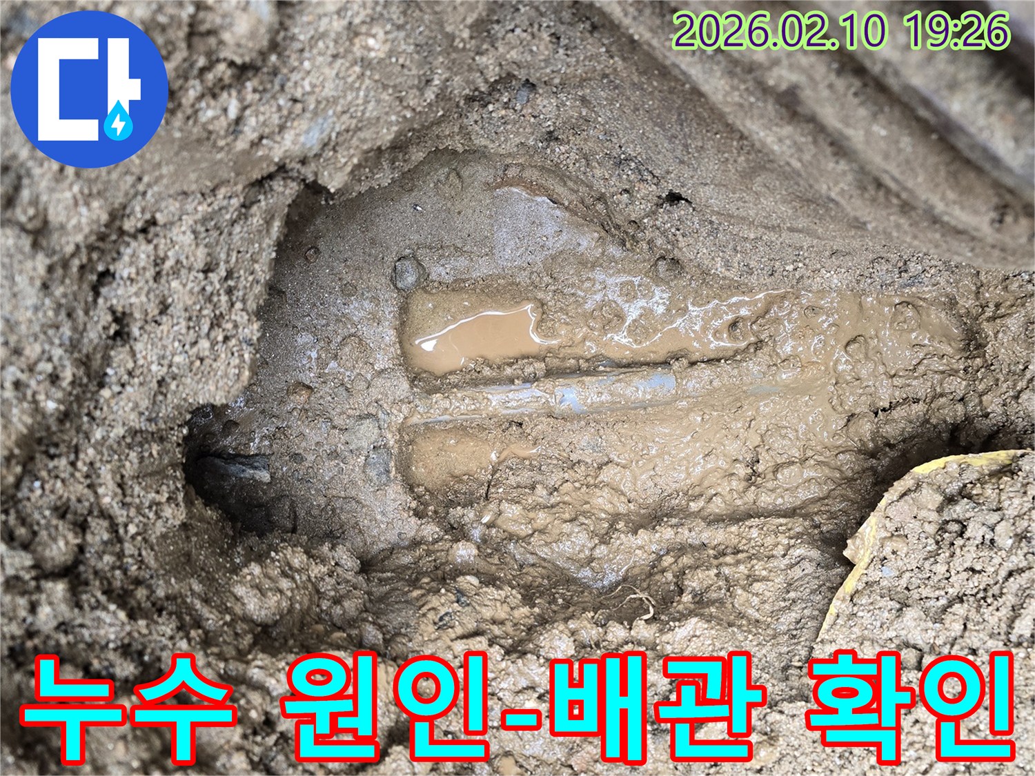 흙을 파헤친 후-물이 고여있는 배관이 드러난-누수 현장의 결정적인 순간