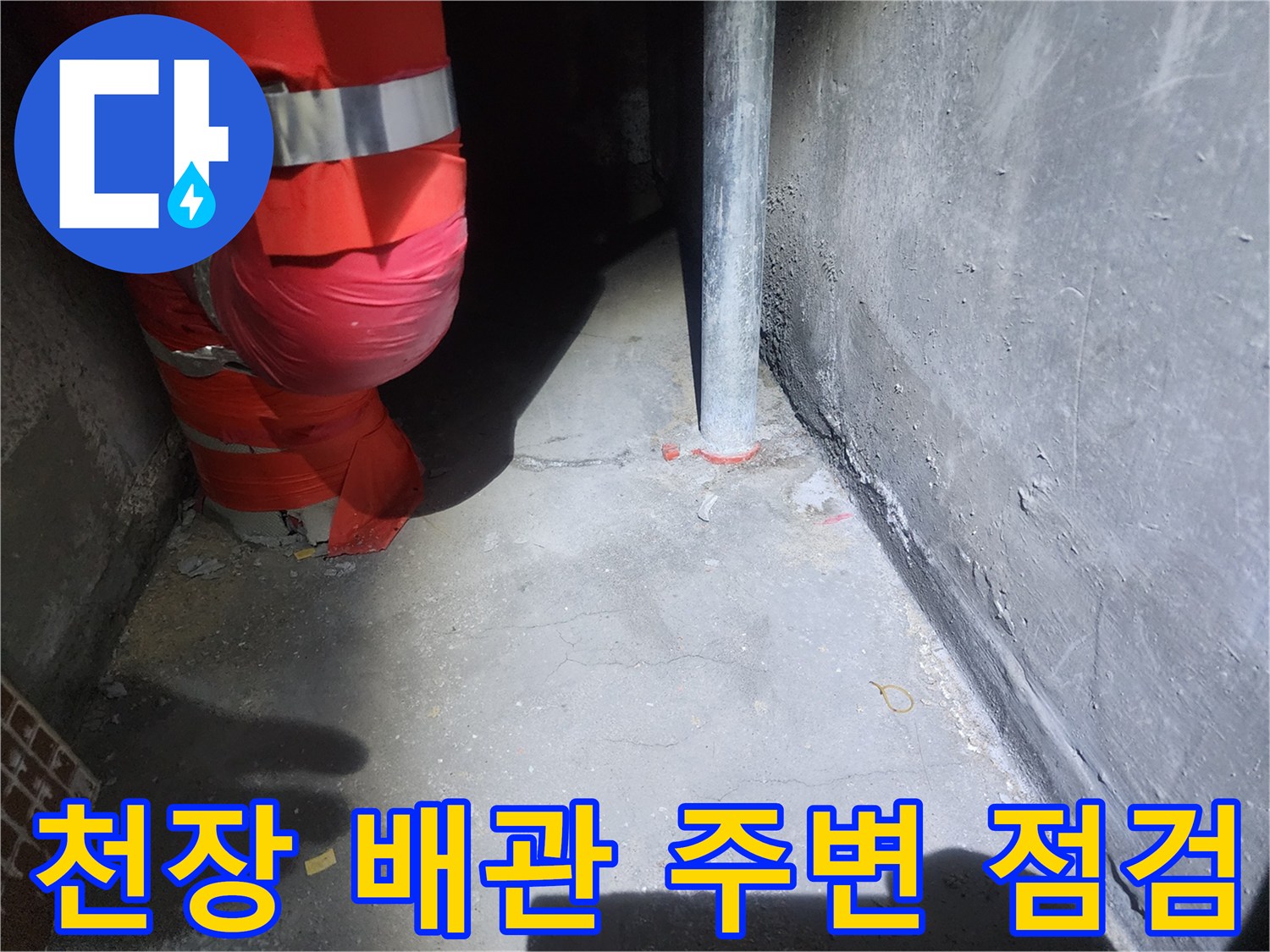 아파트 천장 내부의 수직 배관과 붉은색 보온재가 설치된 모습입니다.