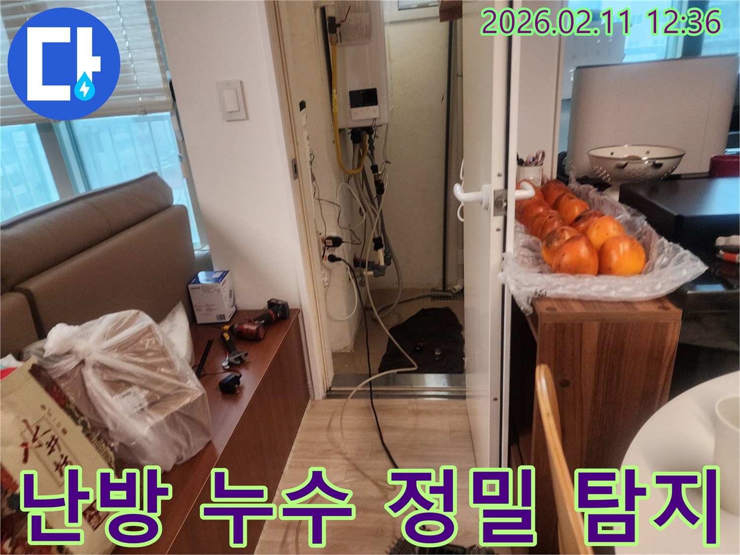 이 이미지는 동대문구 회기로 아파트의 난방 누수를 정밀하게 탐지하기 위해 전문가가 보일러실에서 장비를 사용하는 현장을 보여줍니다.