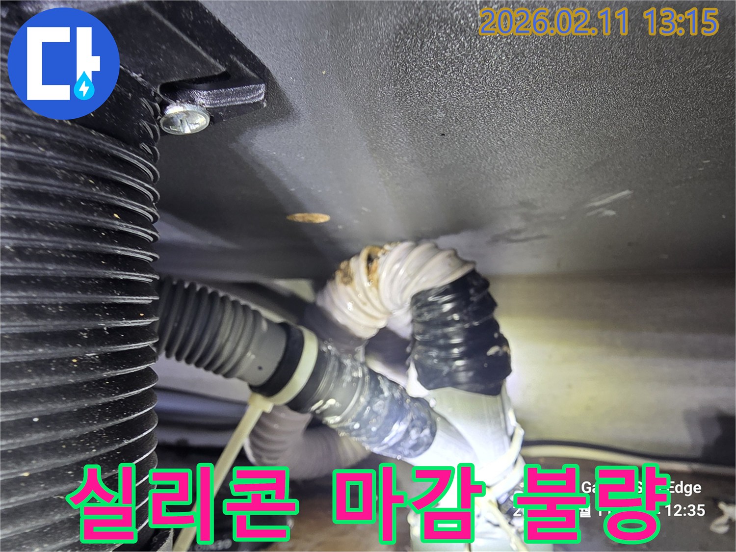 배수관 연결 부위의 실리콘 마감이 불량하여 물이 새는 현장을 담은 사진입니다-실리콘의 손상과 물기가 보입니다