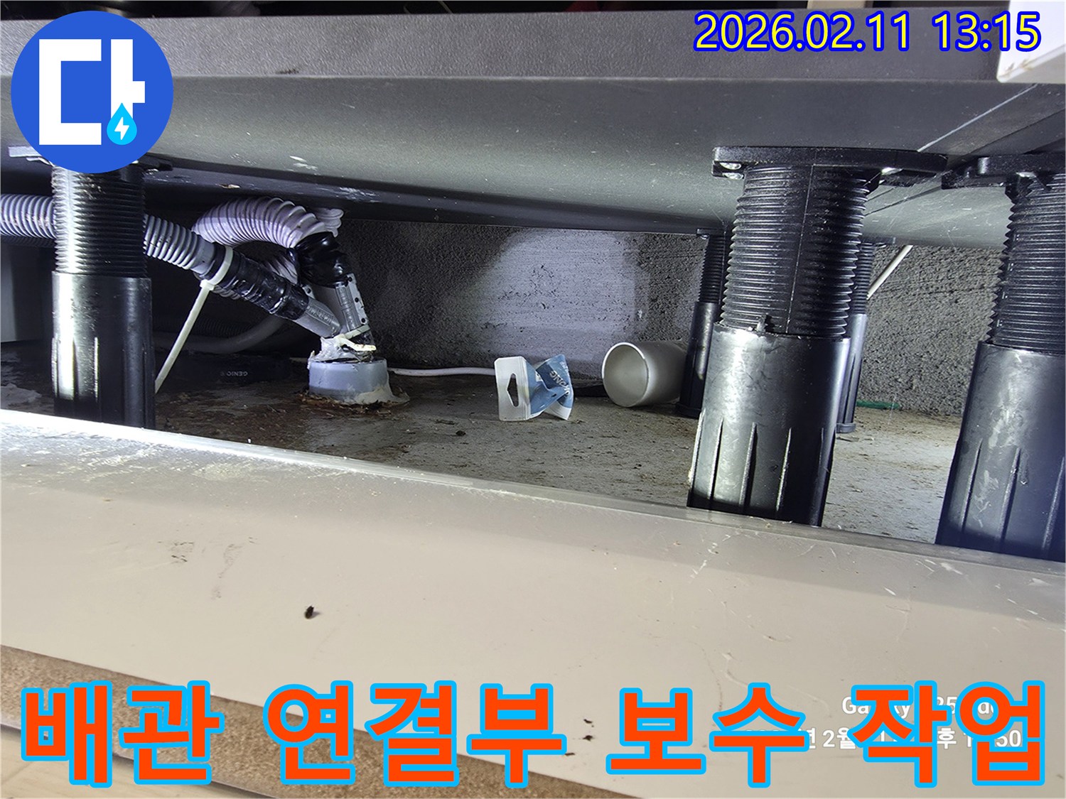 싱크대 하부 배관 연결 부위에서 발생한 누수를-수리하기 위해 보수 작업이 진행되고 있는 현장 사진