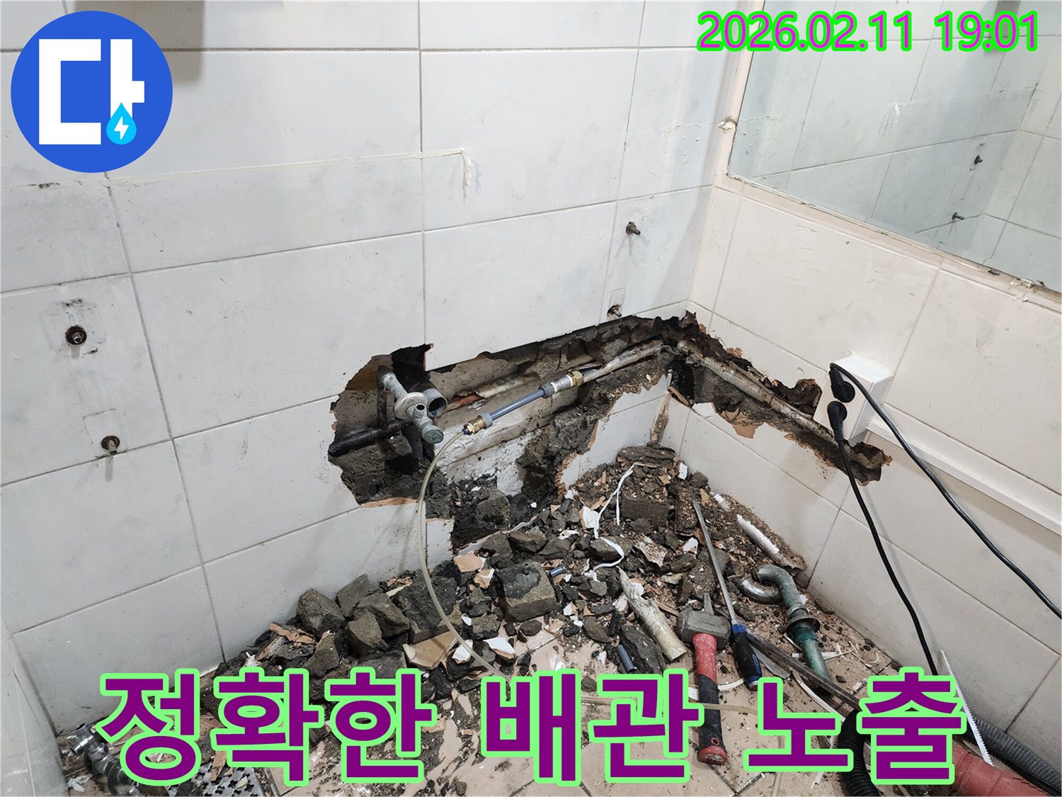 용산구 욕실의-누수 해결을 위해-벽면을 파쇄하고-배관을 정확히-노출시키는-전문가의-작업 현장입니다.