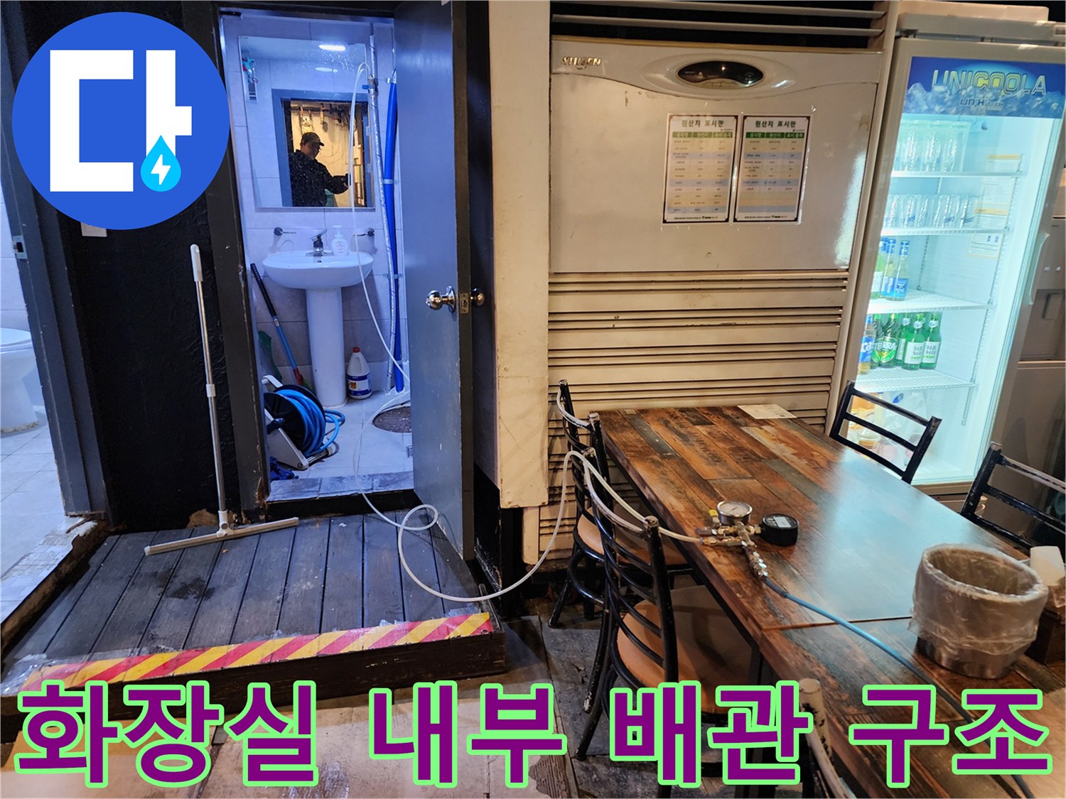 세면대 아래쪽 파란색 관과 바닥으로 이어지는 복잡한 배관 설비 모습