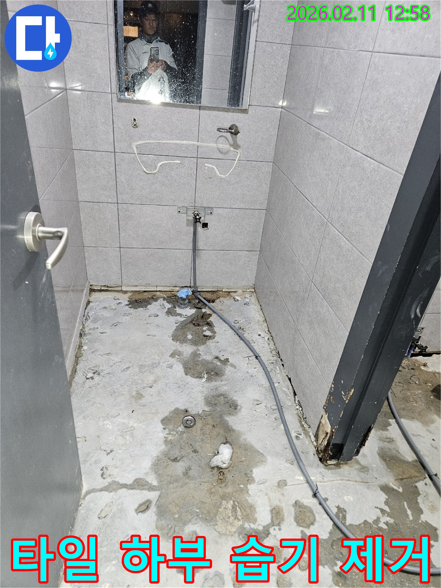 화장실-누수-수리-과정에서-타일-하부의-습기를-제거하고-있는-작업-현장