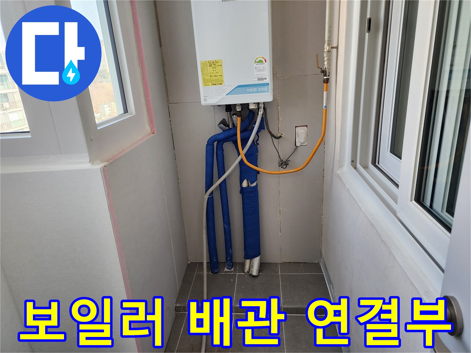 보일러 하단에 연결된 파란색 난방 배관과 노란색 온수 호스 모습