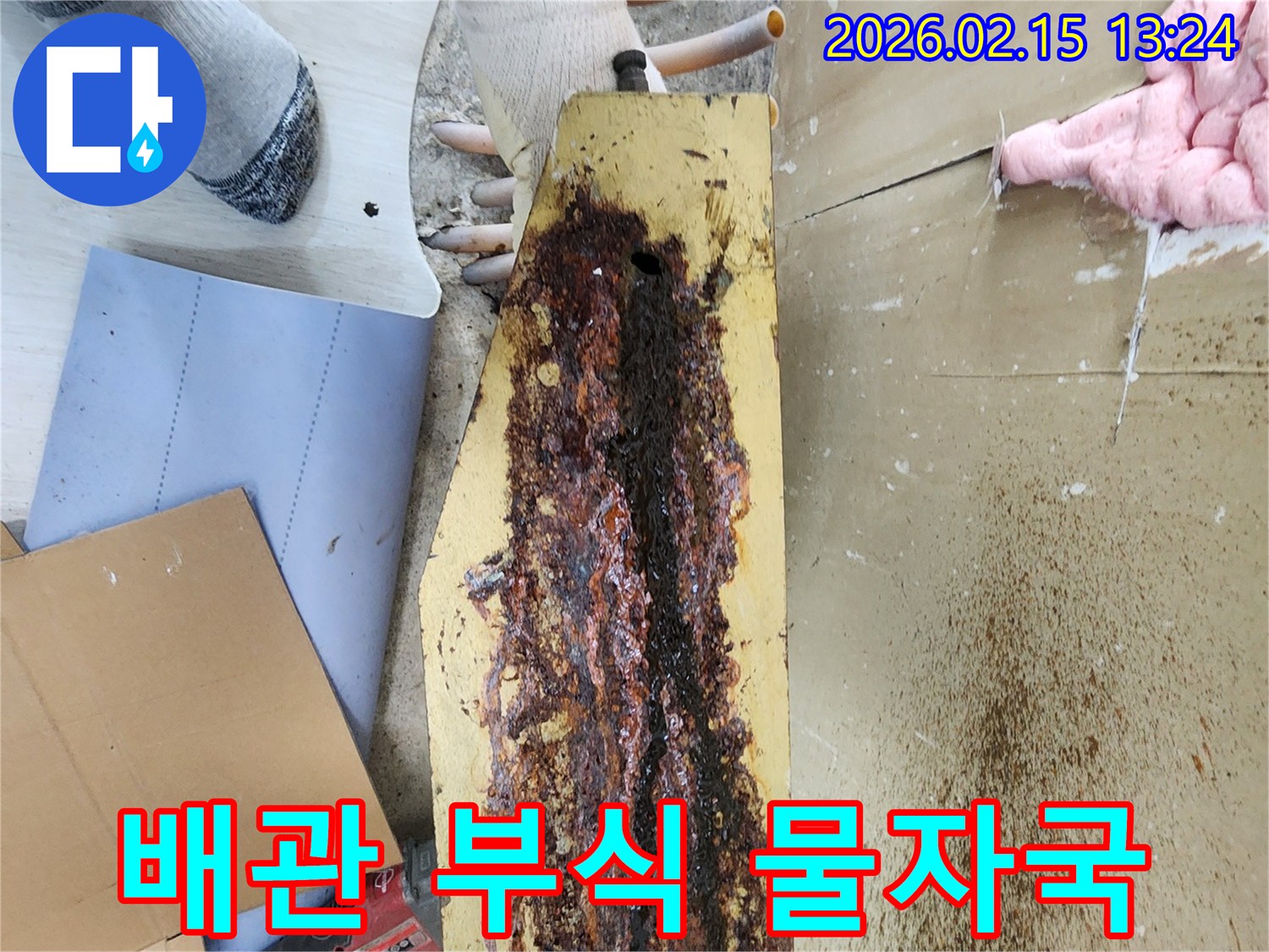 빌라-누수-현장에서-부식된-배관으로-인한-명확한-물자국을-전문가가-확인하고-있습니다