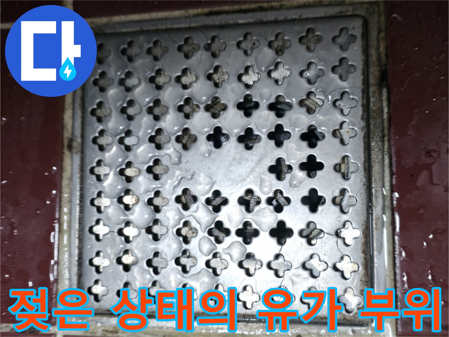 물기가 맺힌 욕실 배수구와 주변 타일 모습