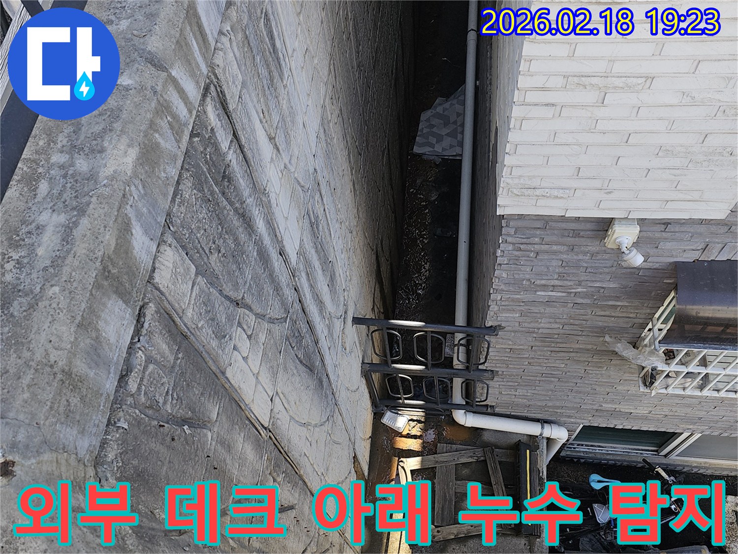 고양시 일산동구 숲속마을 주택 외부 데크 아래에서 발생한-누수의 정확한 원인을 탐지하기 위해 전문가가 현장을 조사하는 모습입니다