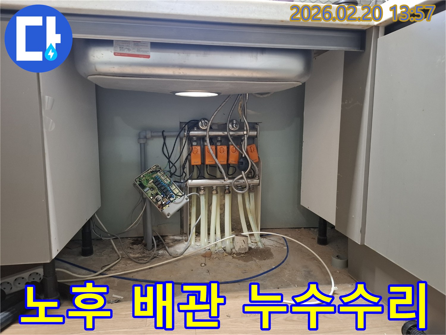 싱크대 하부의 노후된 배관에서-발생한 누수 지점을 정확히 찾아내어-전문 엔지니어가 수리 작업을 진행하고 있습니다