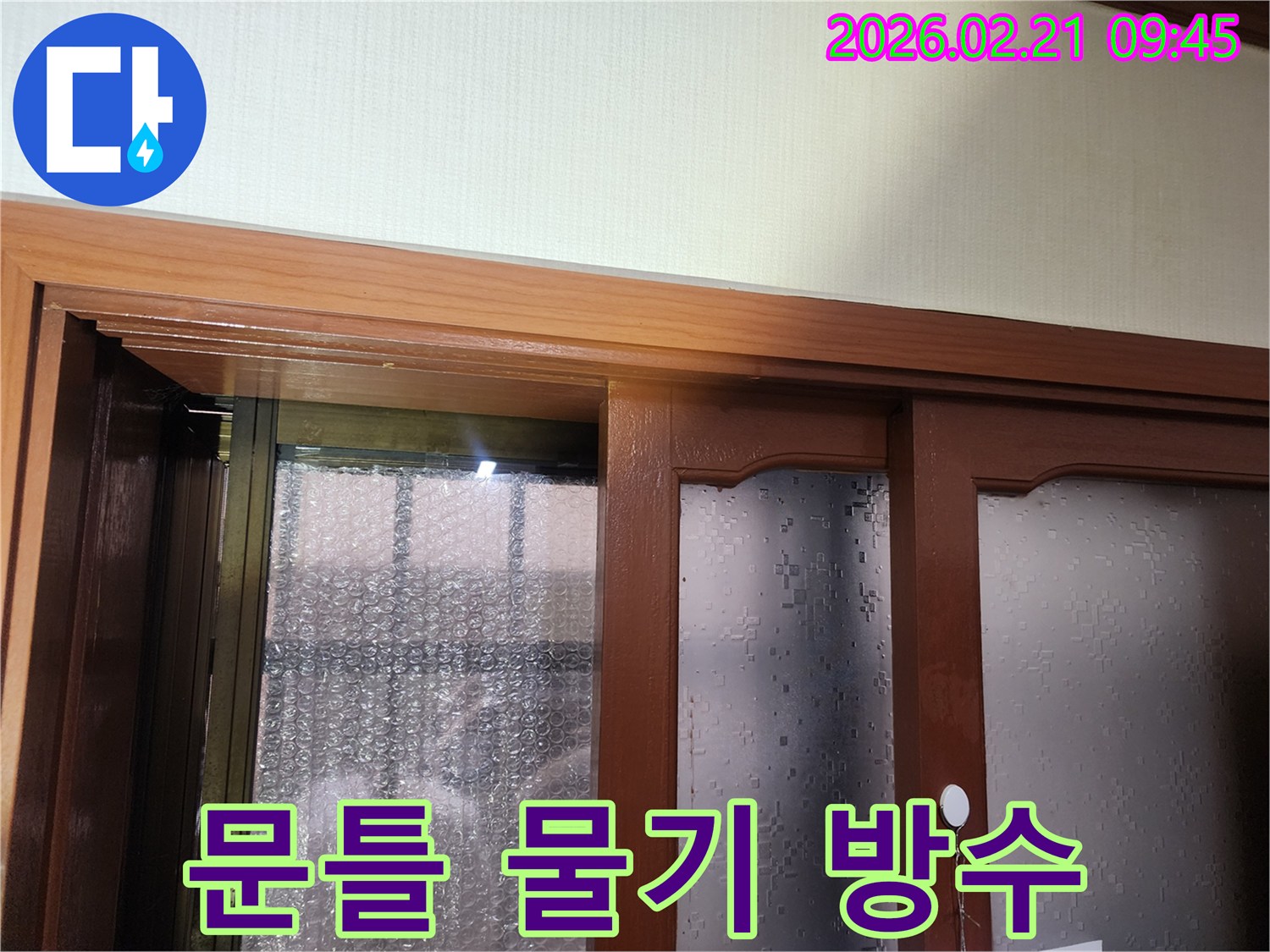 누수-전문가가-문틀-주변-물기를-제거하고-방수-처리를-진행하는-누수-공사-현장
