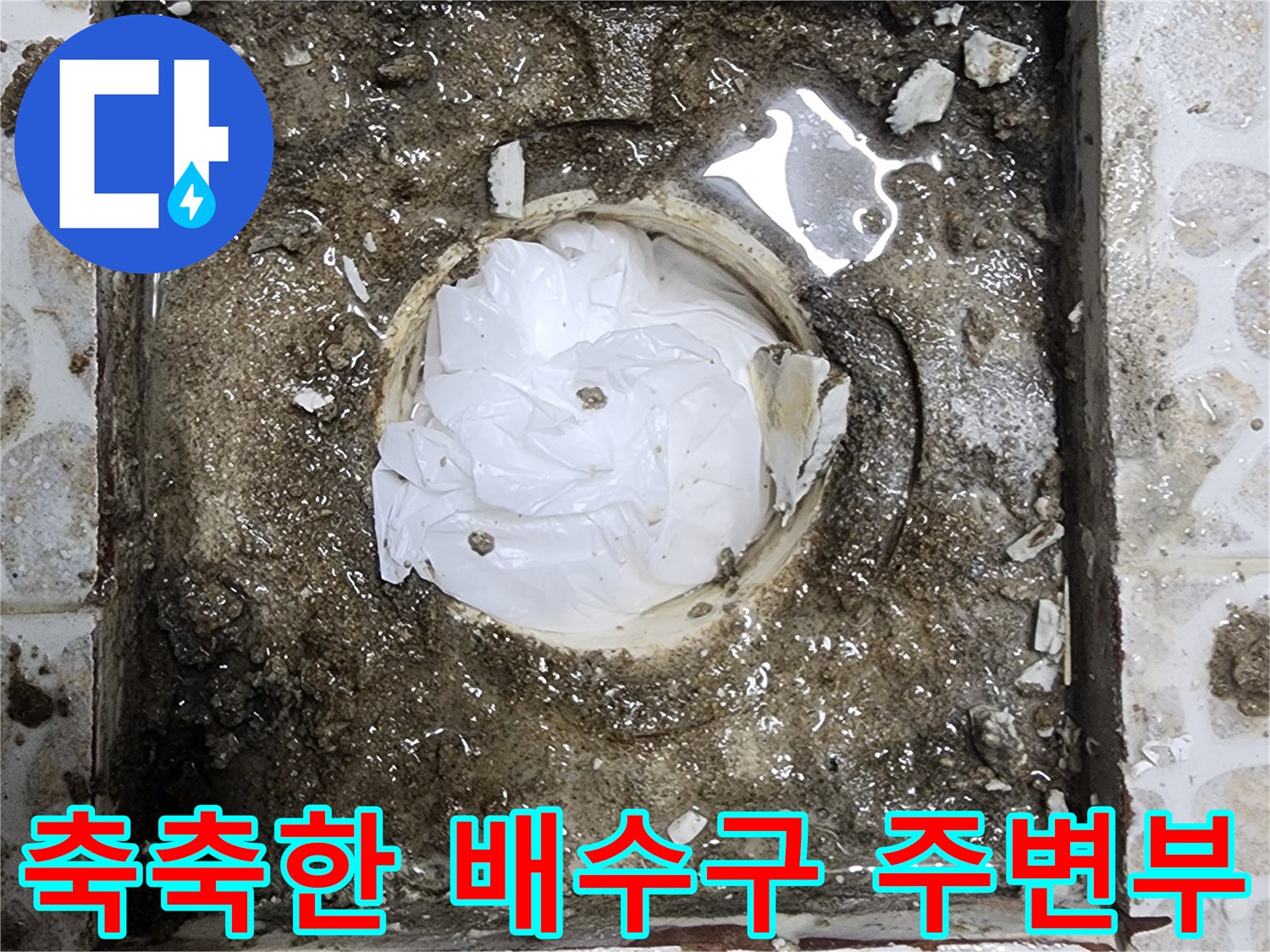 배수구 유가 주변의 젖은 타일과 모래층을 보여주는 사진