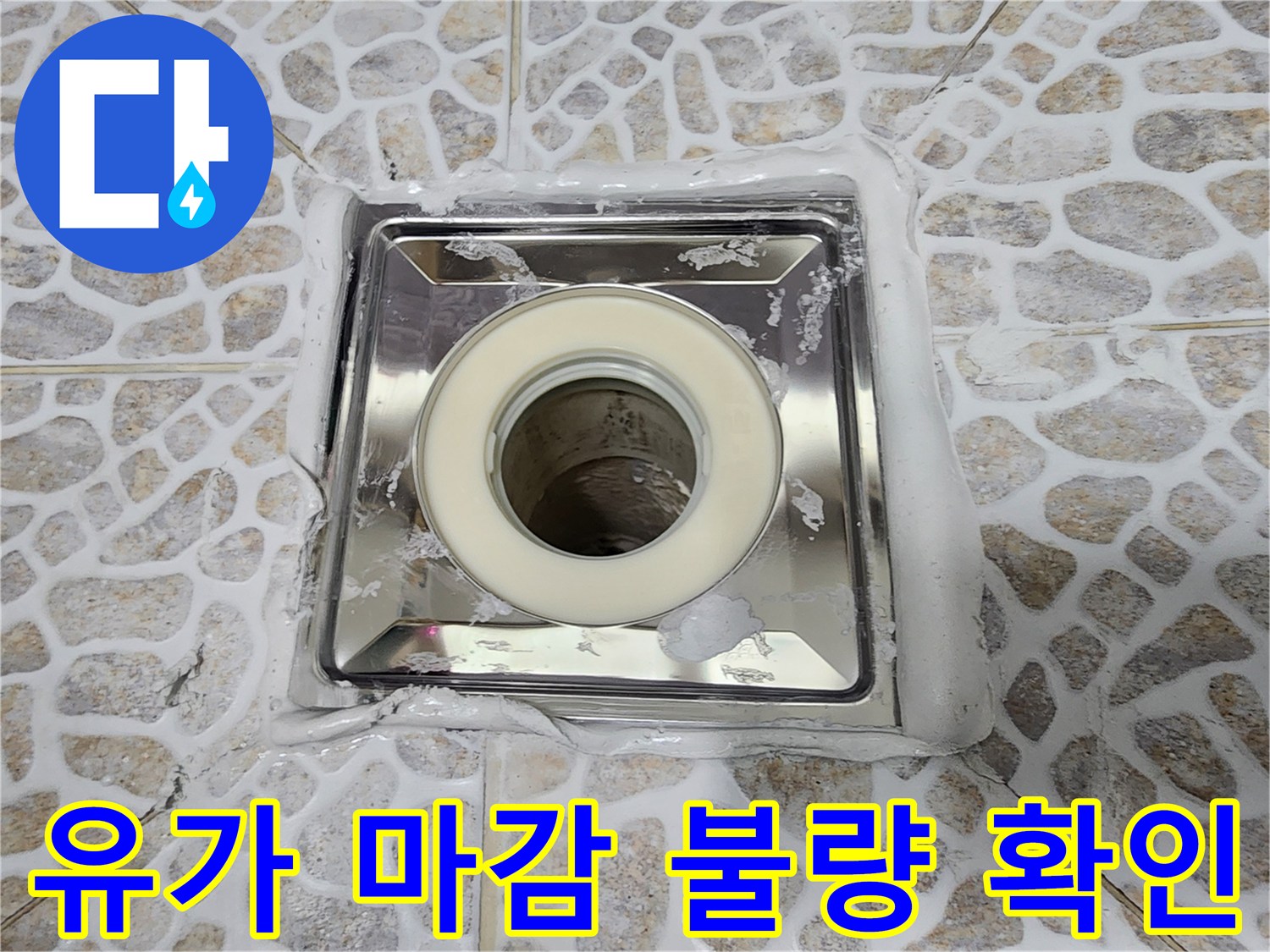 배수구 유가와 타일 사이의 벌어진 틈새를 상세히 보여줍니다.