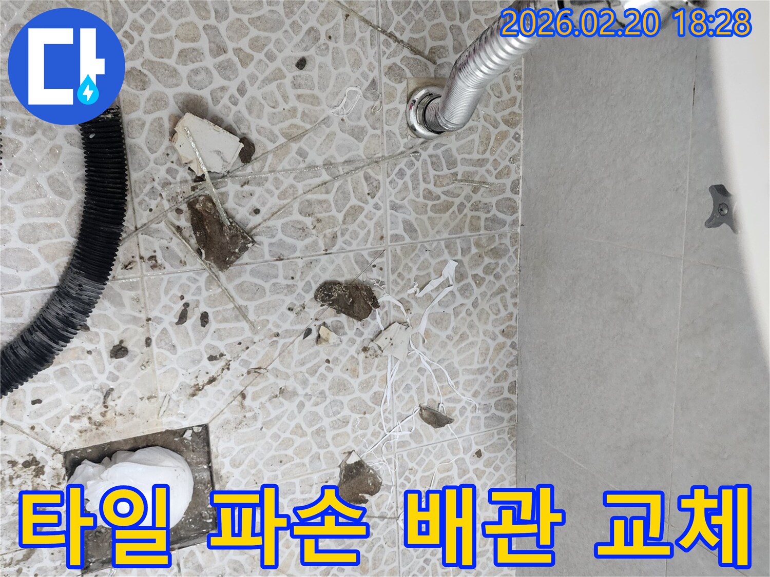 이 이미지는 동대문구 장한로의 한 건물에서 발생한 누수를 해결하기 위해-타일 파손 후-손상된 배관을 교체하는 공사 현장을 보여줍니다.