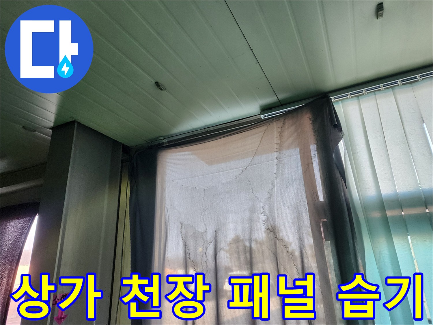 천장 패널과 커튼이 있는 상가 내부의 점검 현장입니다.