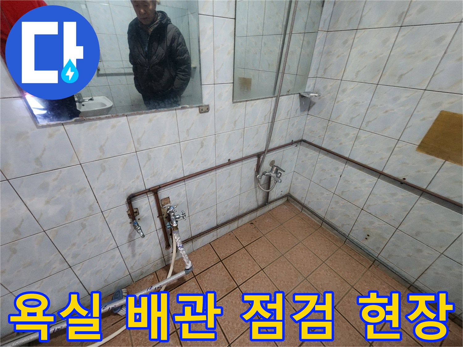 화장실 벽면의 노출된 배관과 타일 상태 촬영