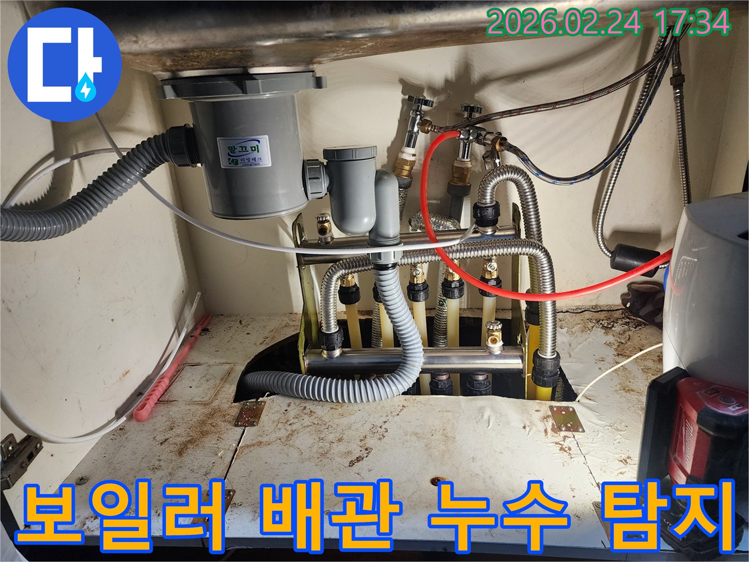 싱크대 하단에-위치한-보일러-분배기-및-배관에서-누수를-정확히-탐지하는-전문가의-작업 모습