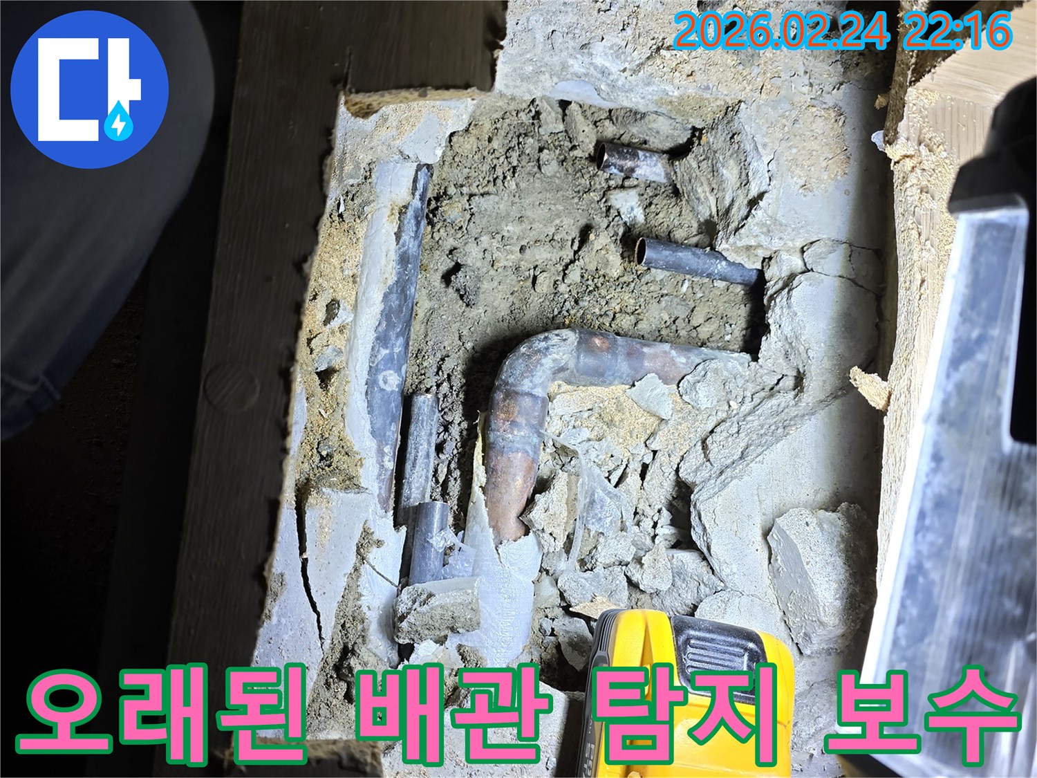 손전등으로 밝혀진-오래된 배관에서-누수 지점을-정확히 찾아내어-보수 작업을-준비하는 현장입니다.