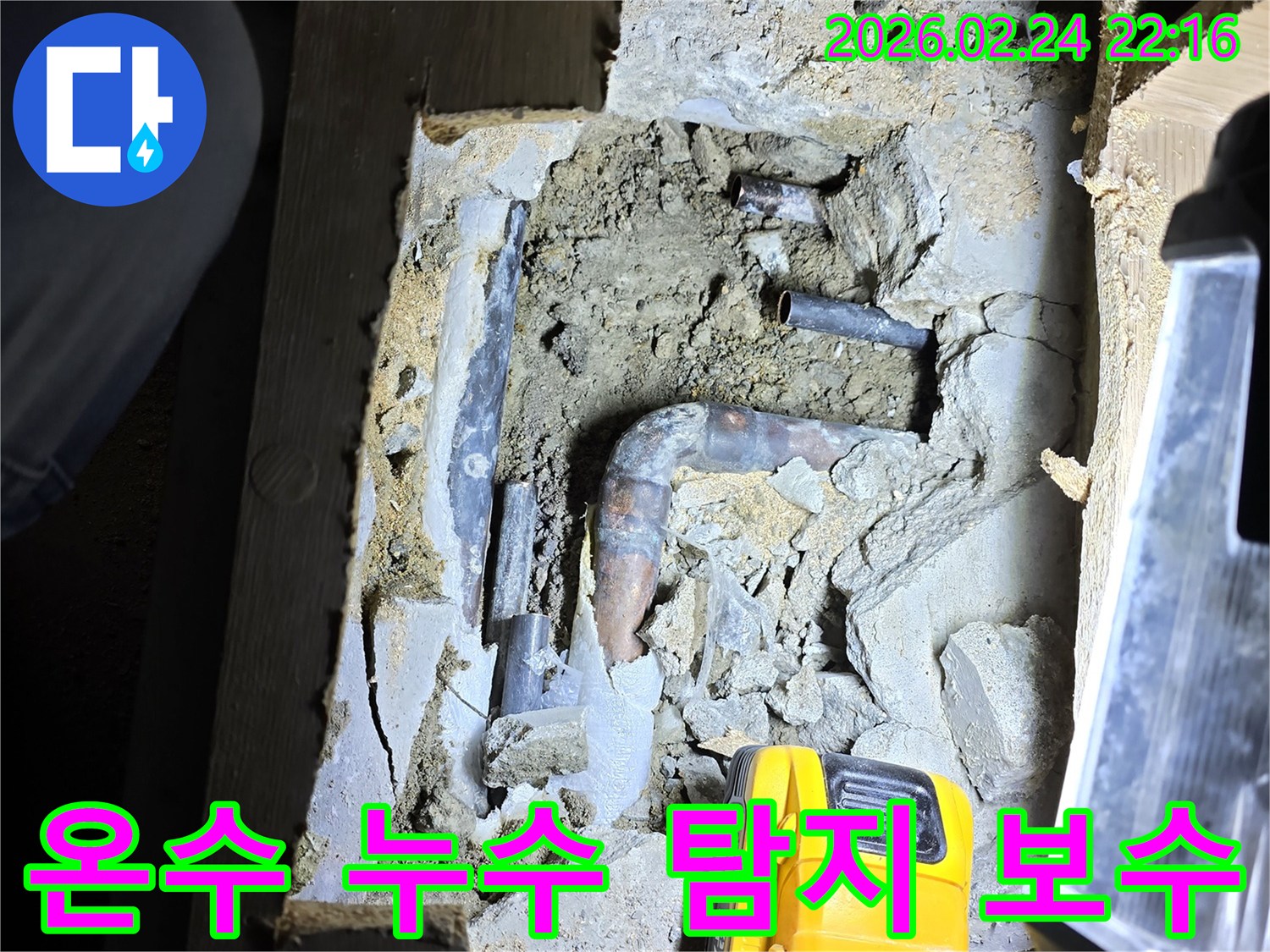 손전등으로 밝혀진-오래된 온수 배관에서-누수 지점을-정확히 찾아내어-보수 작업을-준비하는 모습입니다.