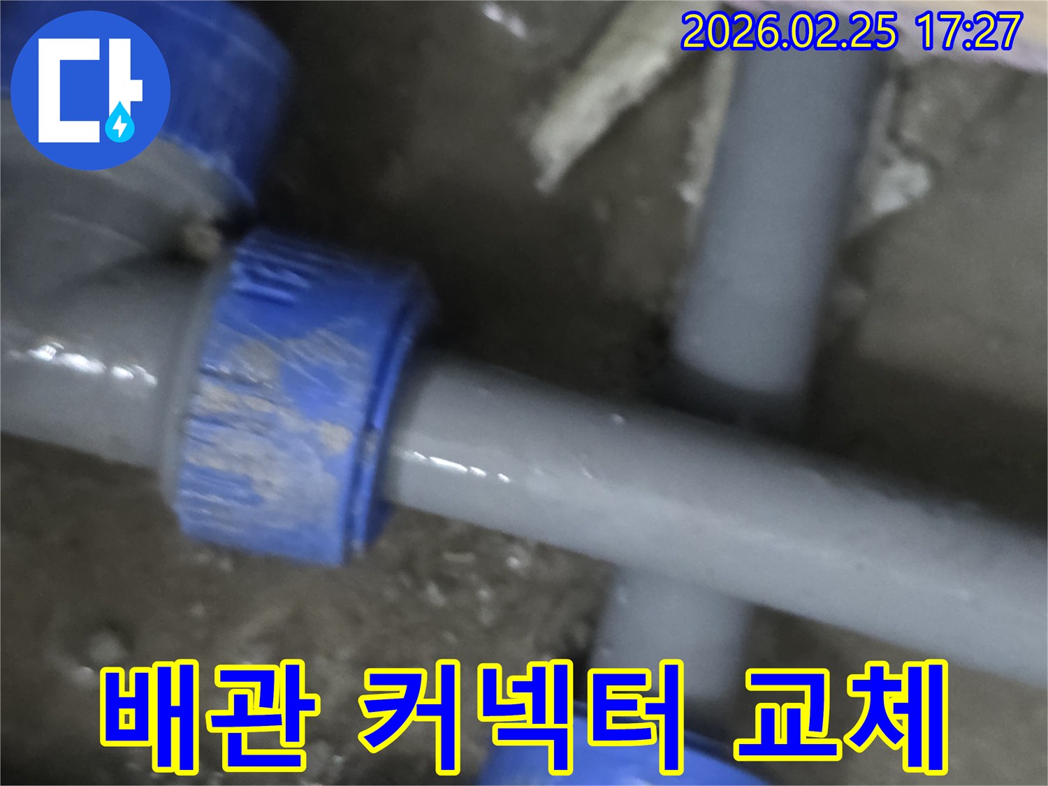 누수가 발생한 배관의 파란색 커넥터를-새로운 부품으로 교체하는-전문적인 수리 현장의 모습입니다.