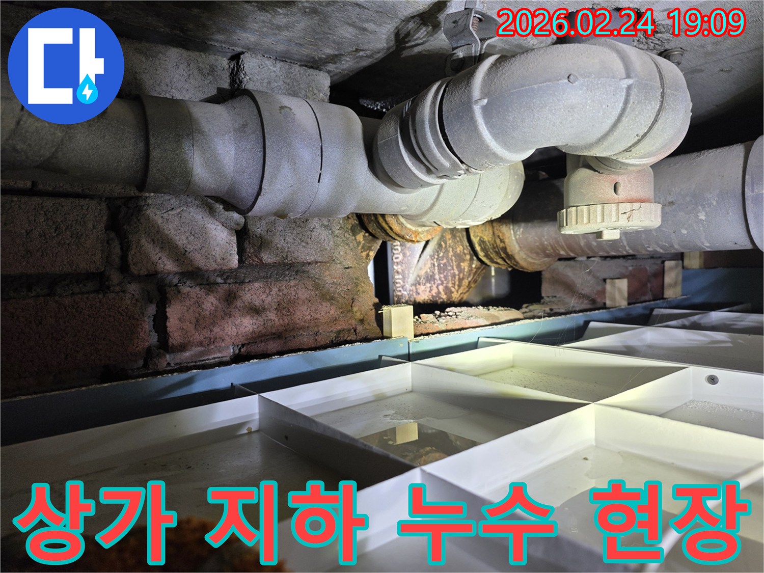 상가-건물-지하의-노후-배관에서-누수가-발생하여-물이-고인-상황을-보여주는-이미지