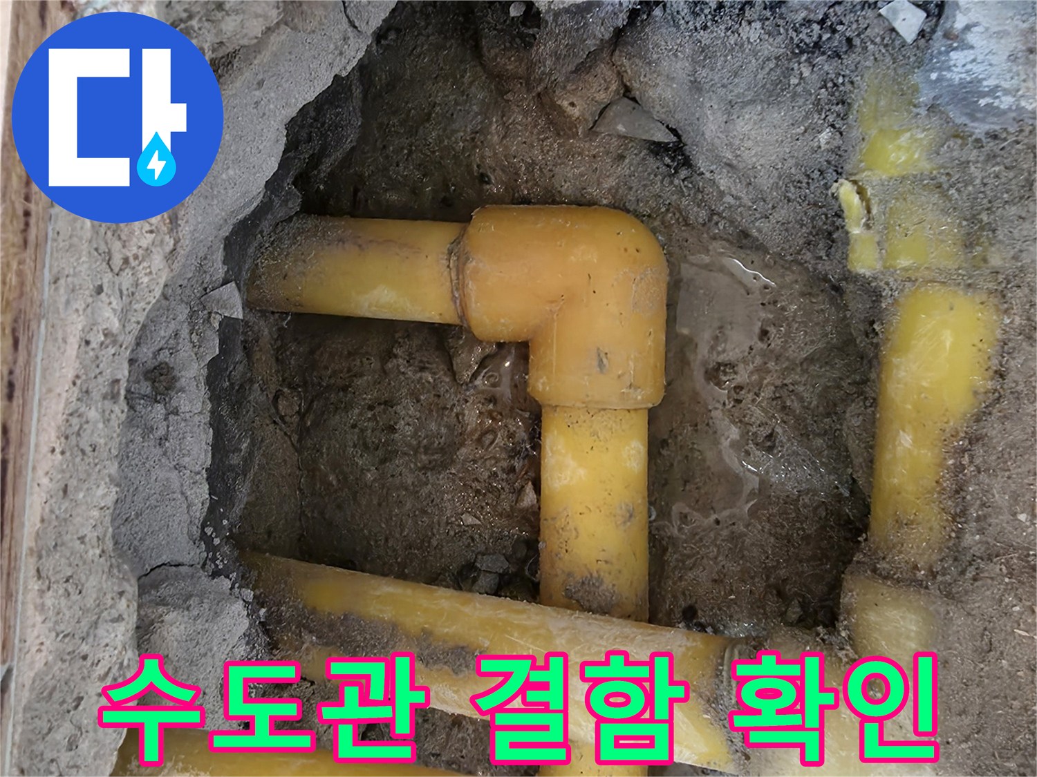 젖은 흙 속에 노출된 노란색 수도 배관 연결 부위