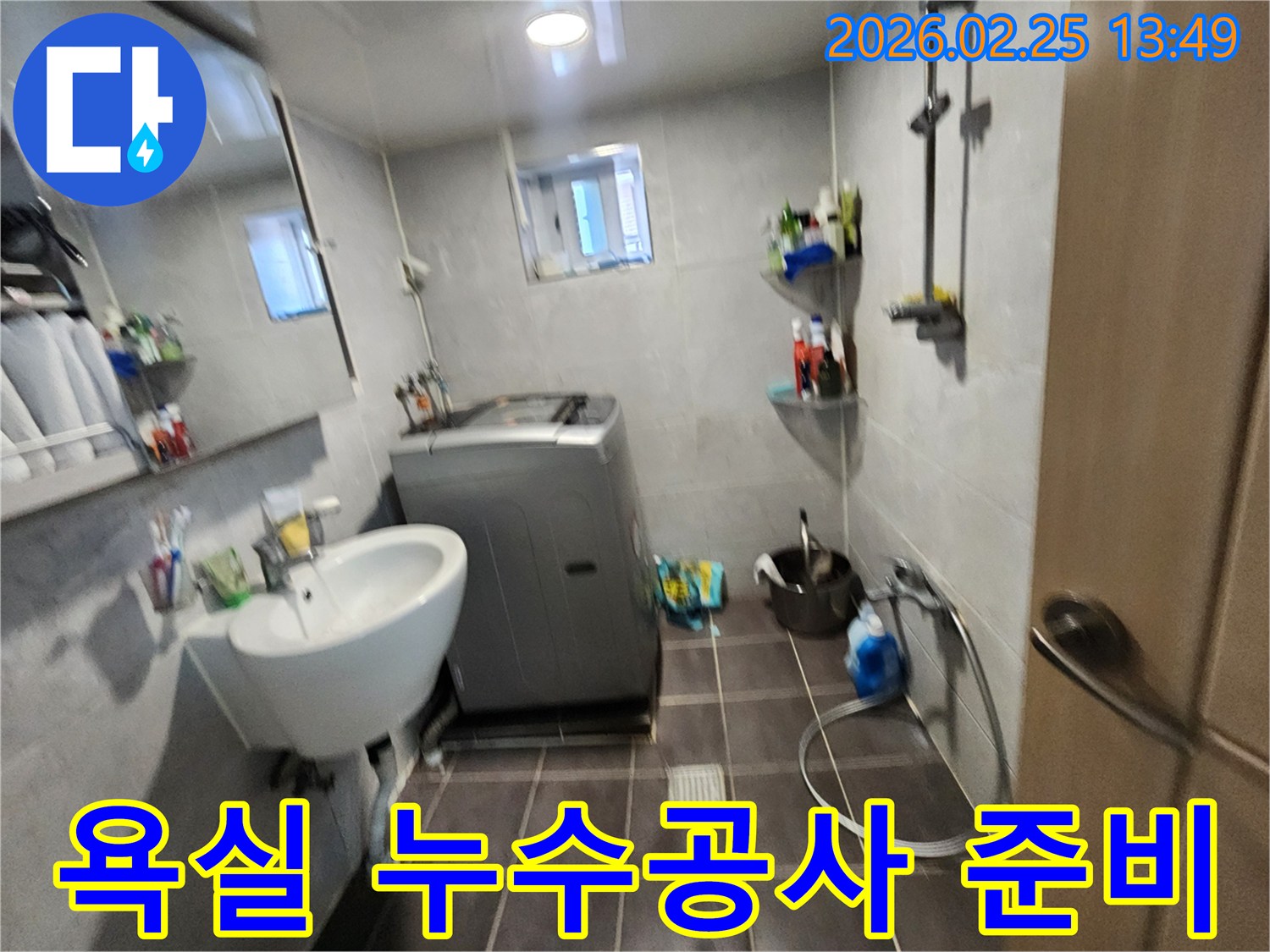 세탁기와-세면대가-있는-욕실에서-누수공사를-위해-현장을-준비하는-모습을-담은-사진