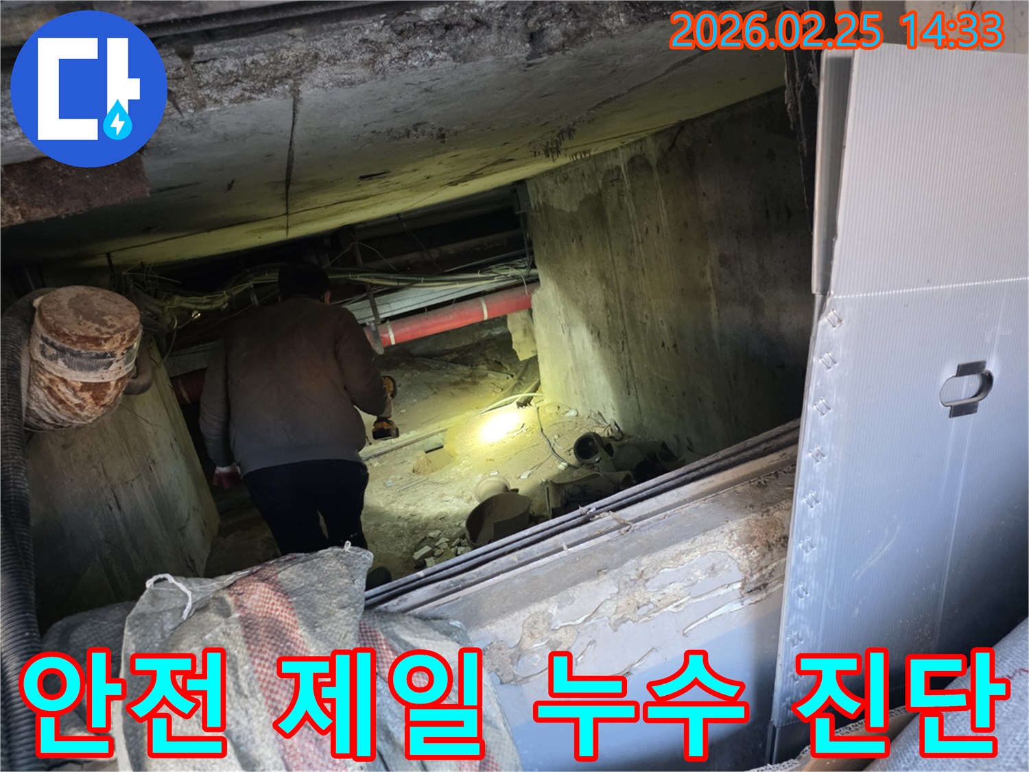 누수 전문 엔지니어가-어둡고 좁은 공간에서-안전 수칙을 준수하며-손전등을 비춰가며-누수 지점을 정확히-진단하는 모습입니다.