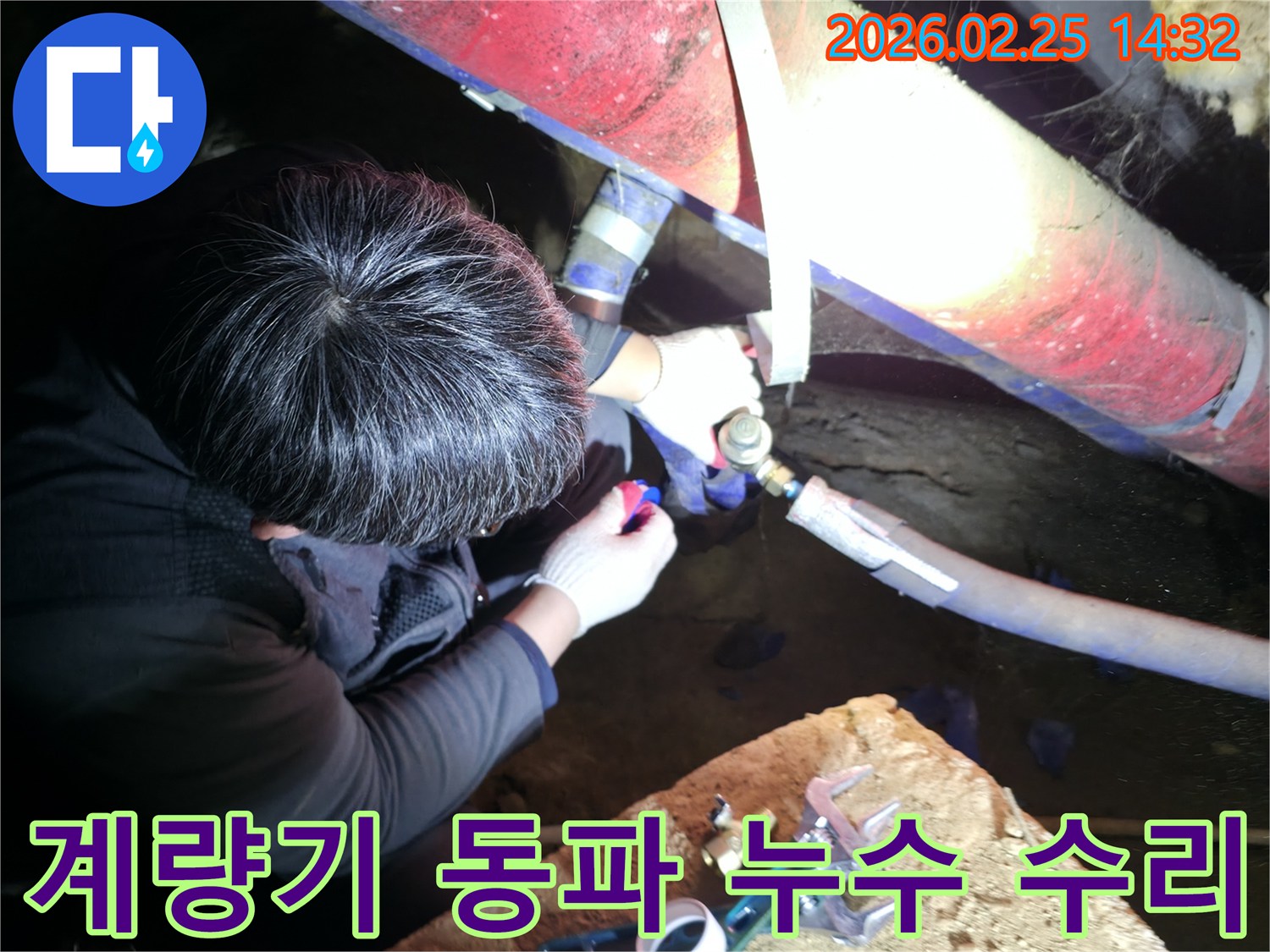 숙련된 누수 기술자가 좁은 공간에서 손전등을 비추며 수도-계량기 주변 배관을 정밀하게 점검하고-동파 방지 및 누수를 수리하고 있습니다-수도누수해결-전문가수리