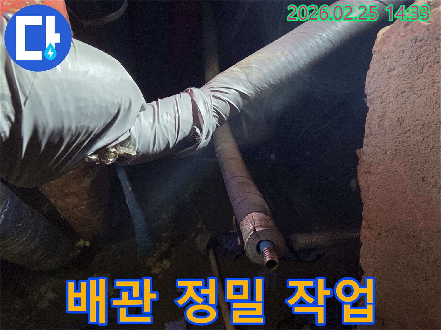 어두운 작업 공간에서-장갑을 낀 엔지니어의 손이-손상된 배관을-매우 섬세하고-정교하게 다루며-수리하는 모습입니다
