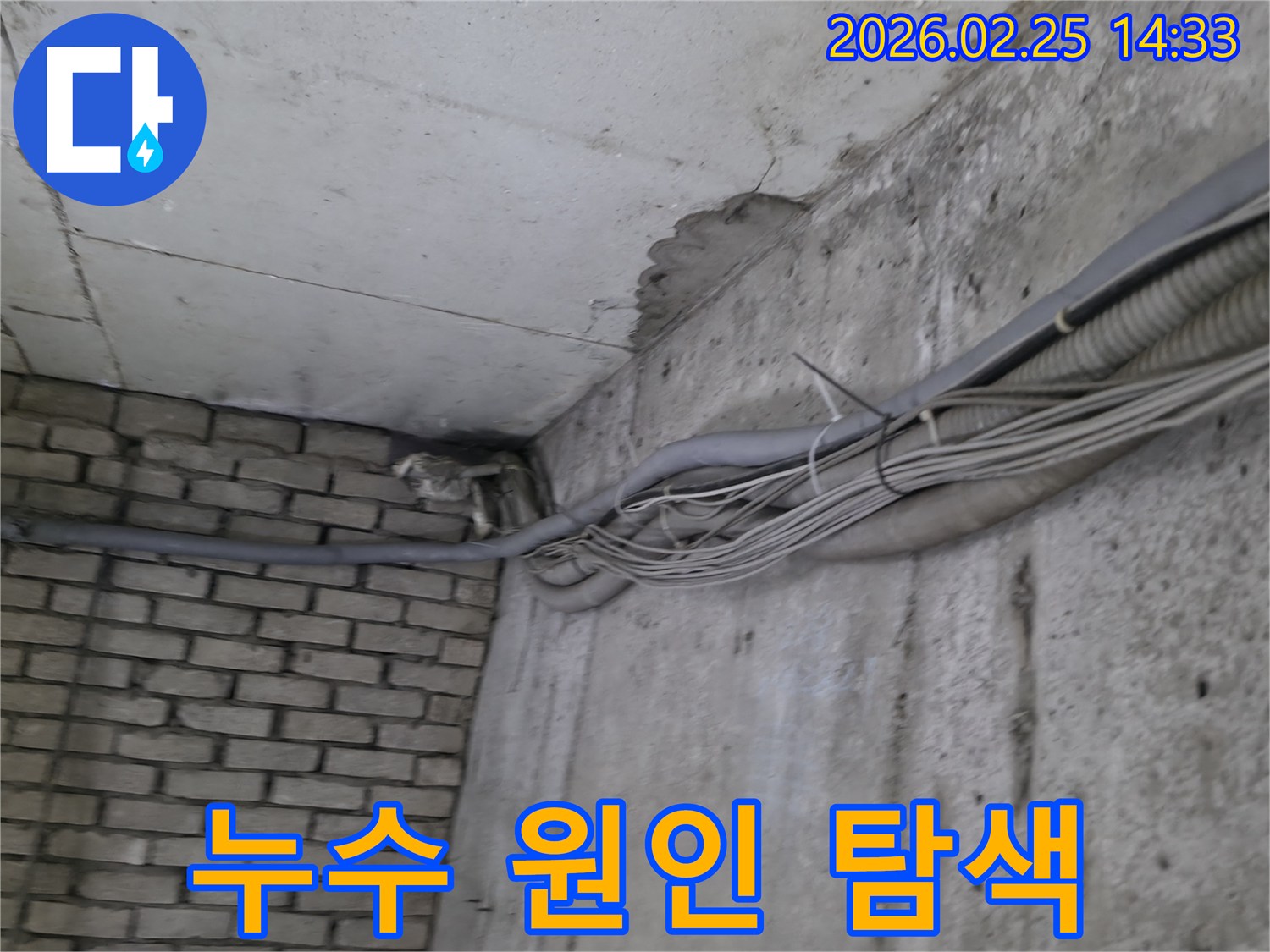 지하 벽면의-콘크리트와-벽돌 벽이 만나는-지점에서-발견된-오랜 누수로 인한-물자국과-주변의 복잡한 배관