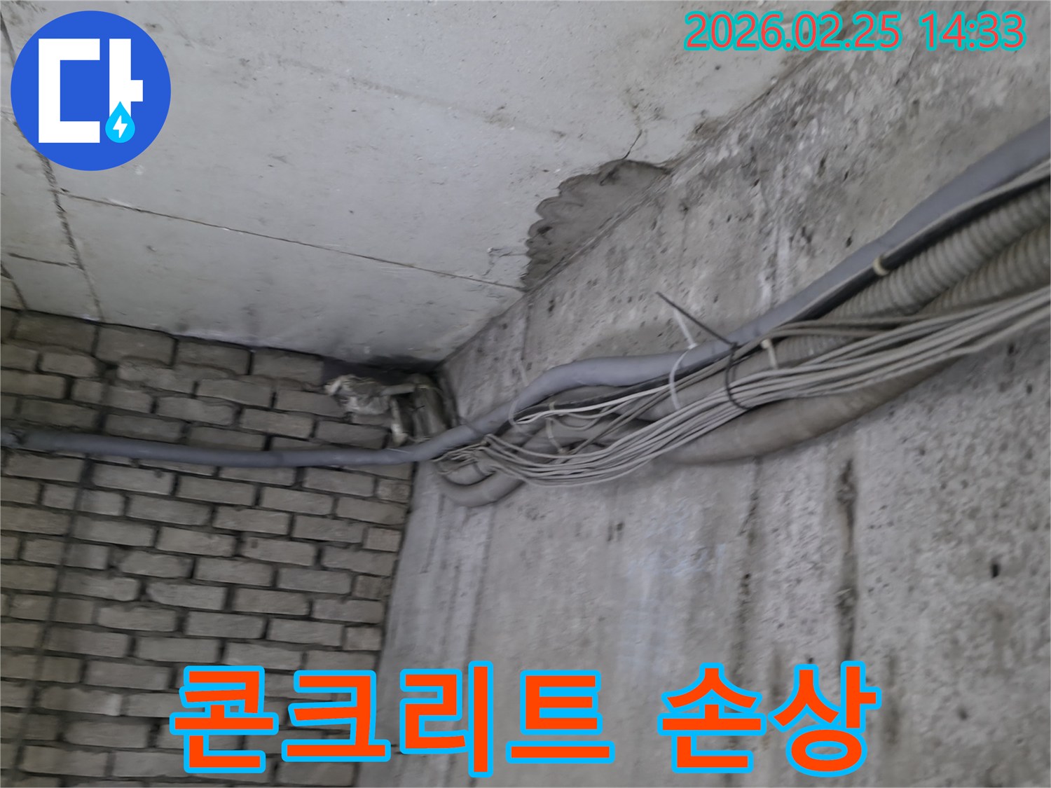 지하 벽면의-콘크리트와-벽돌 벽이 만나는-지점에서-발견된-오랜 누수로 인한-물자국과-주변의 복잡한 배관