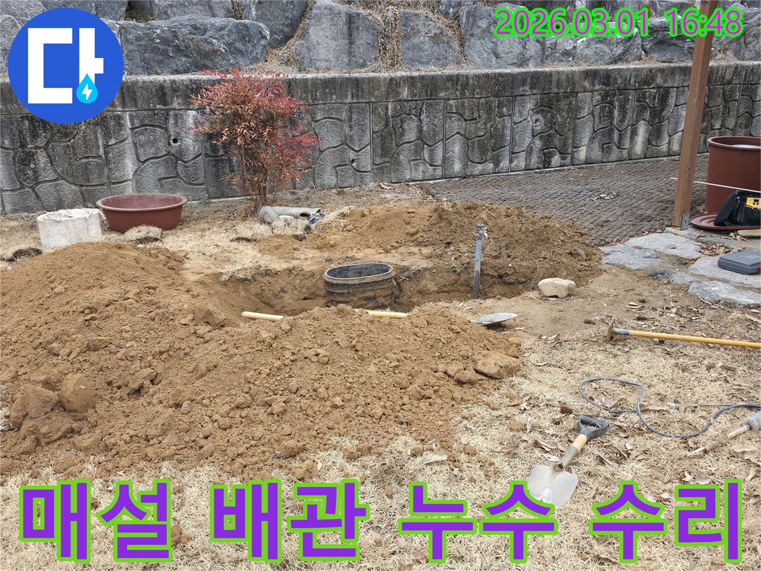 땅속에 매설된 배관의 누수 지점을 탐지한 후-수리를 위해 흙을 파고 있는-작업 현장입니다.