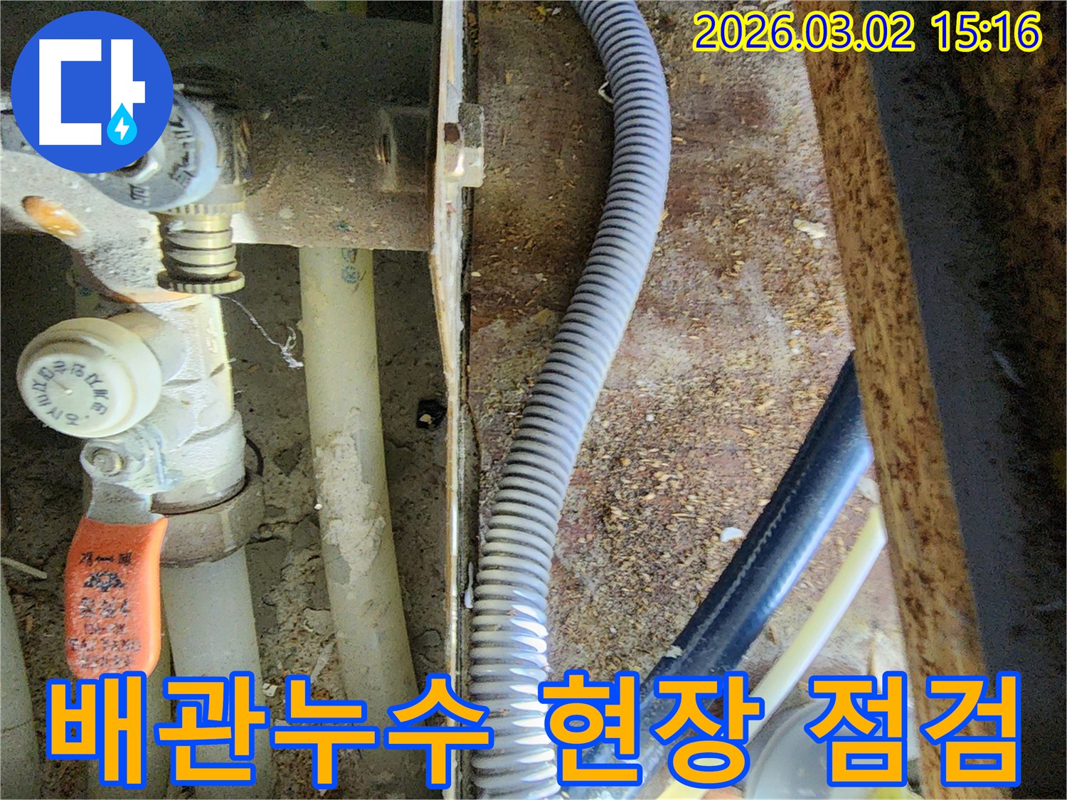 누수 공사 중 발견된 복잡한 배관과 파이프-그리고-주변의 흙먼지 모습