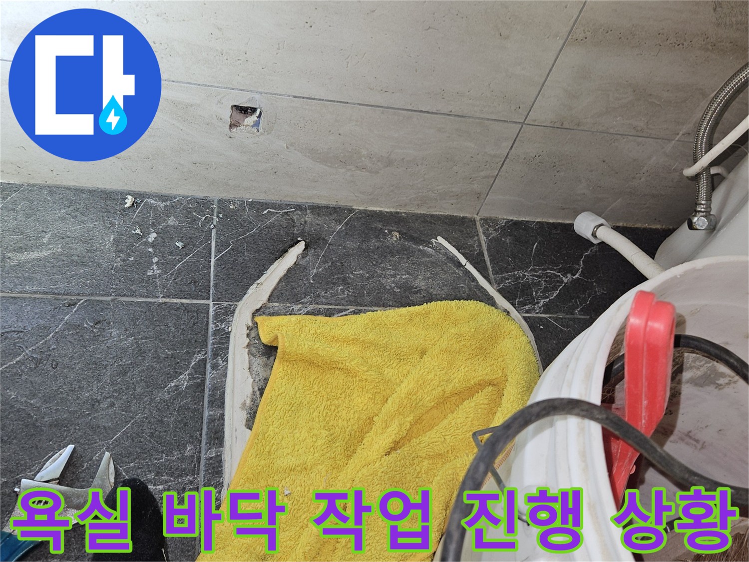 공사 중인 욕실 타일 틈새와 노란 수건의 모습