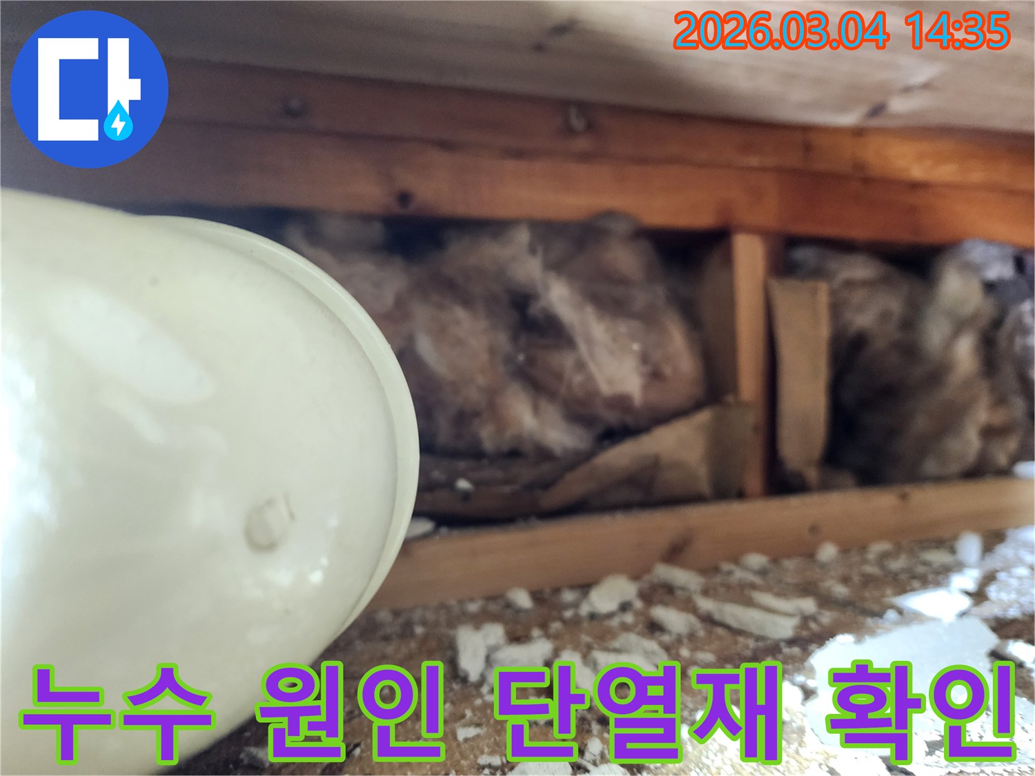 누수 엔지니어가-누수 원인을 파악하기 위해-천장 내부의-젖은 단열재와-배관 상태를-면밀히 관찰하는-모습을 담은 사진