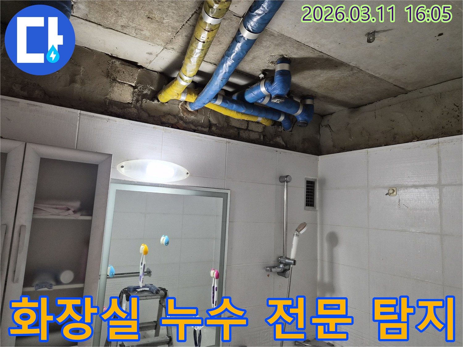 공릉동 화장실 천장의-파란색과 노란색 배관들에서-발생한 누수를-전문가가 첨단 장비로-정확하게 탐지하고-보수하는 현장입니다.
