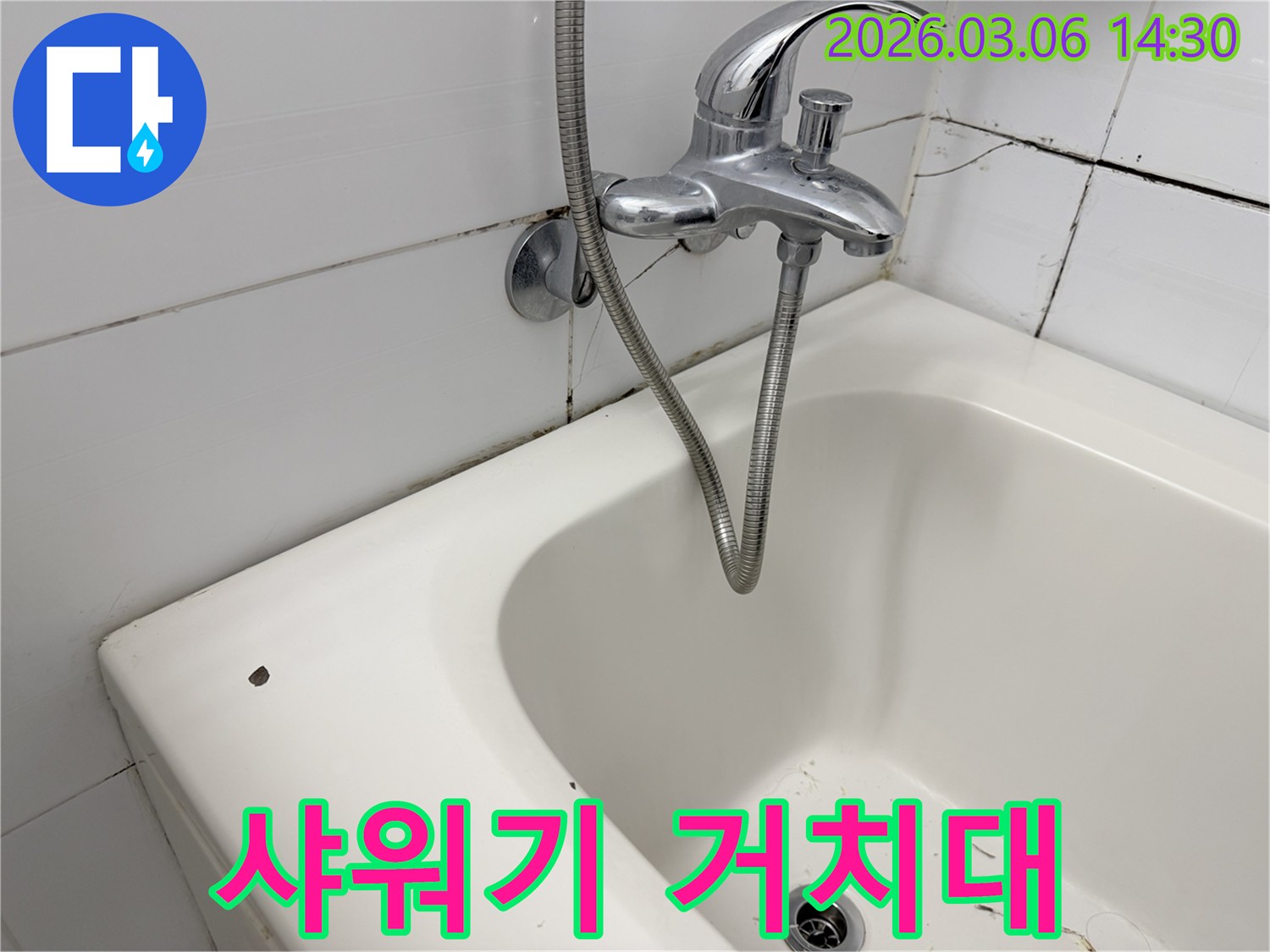 샤워기 거치대 주변의-벽면 타일과-곰팡이-그리고 누수 흔적을 보여줍니다.