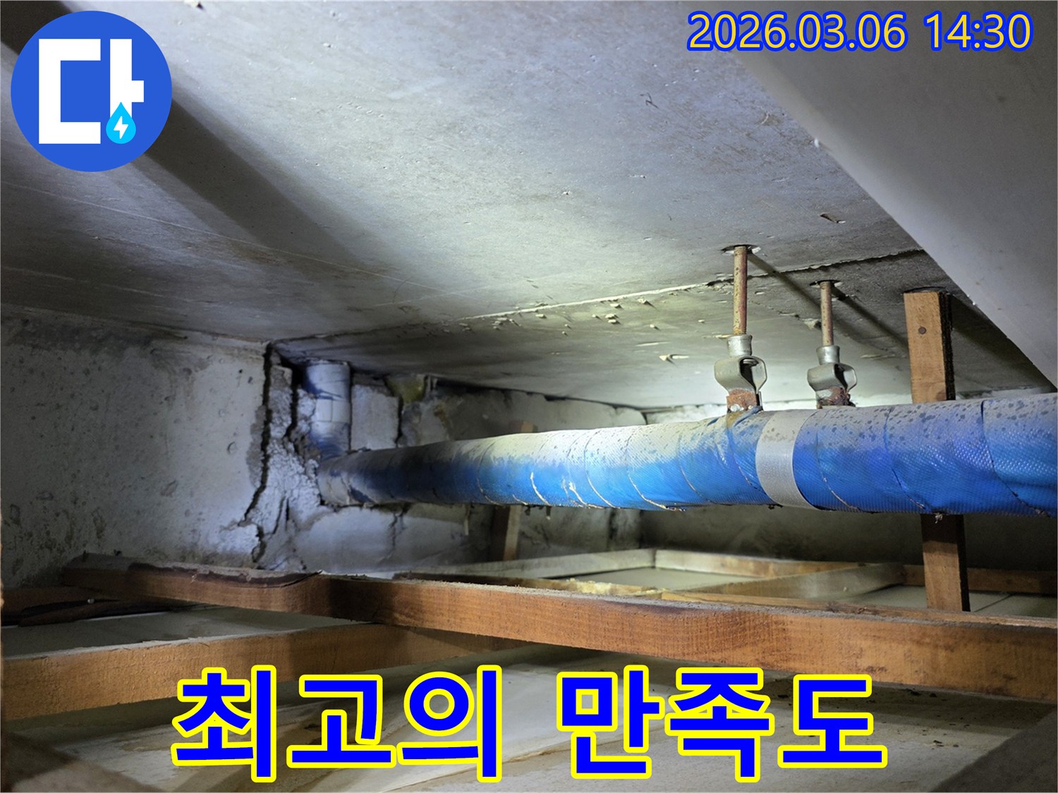 지하 공간의 파란색 배관과-손상된 콘크리트 벽면을-누수 엔지니어가-점검하며 최고의 만족도를-위해 노력하는 모습